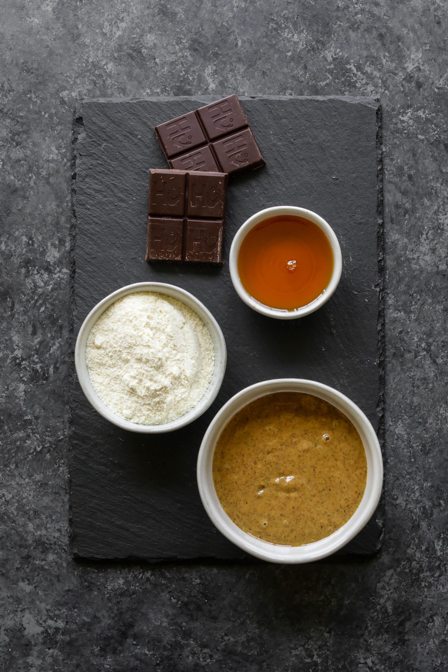 dark chocolate, maple syrup, coconut flour, and nut butter in bowls