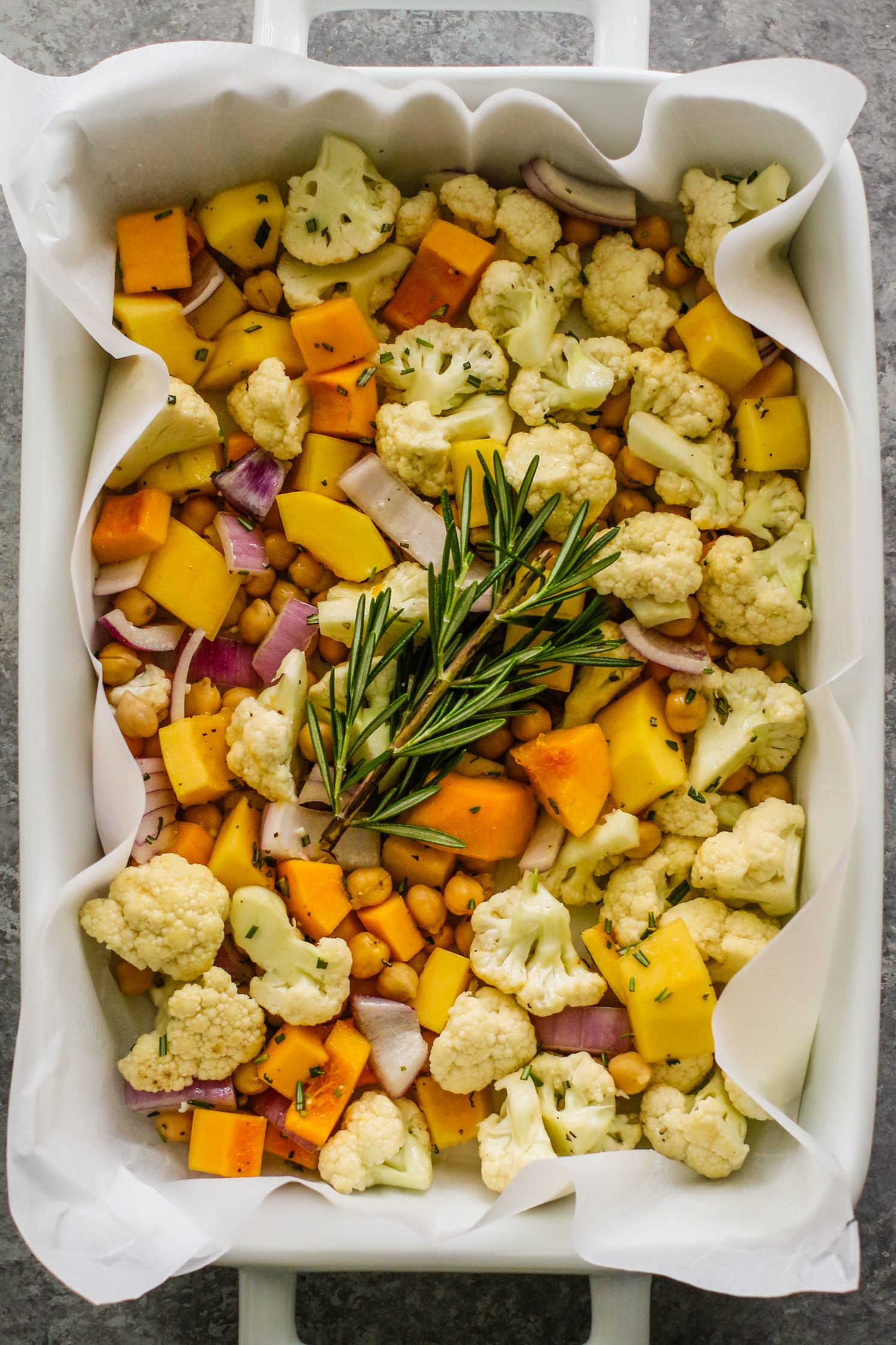 Rosemary Roasted Cauliflower Salad in oven pan with rosemary spring by Flora & Vino
