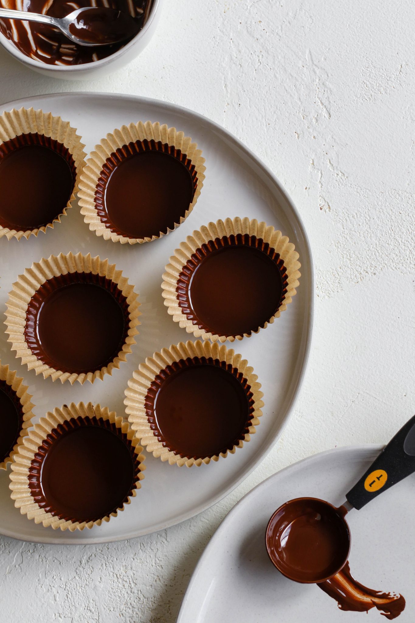 melted dark chocolate in baking cups on plate by Flora & Vino