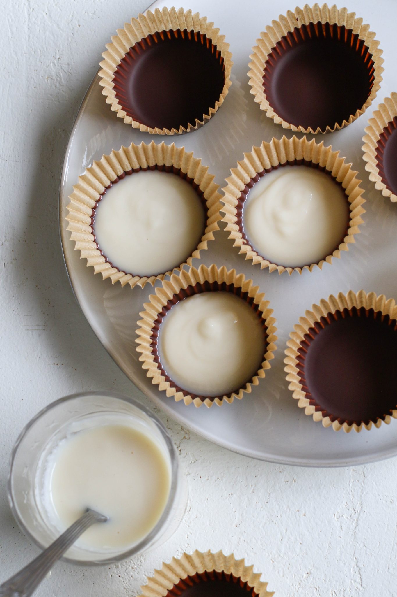 coconut butter poured onto chocolate cups in muffin liners by Flora & Vino
