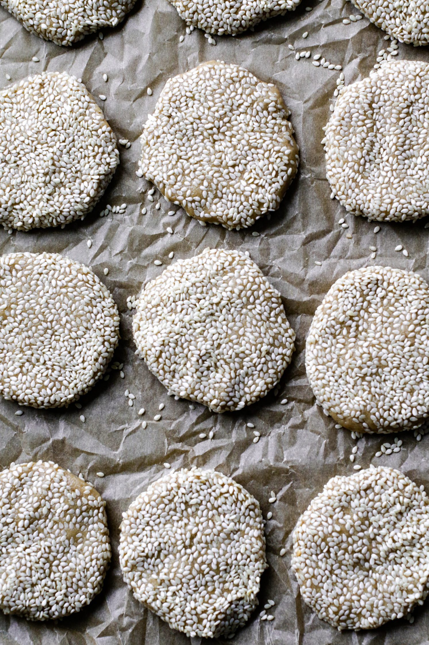 raw Maple Sesame Tahini Cookies on parchment paper by Flora & Vino