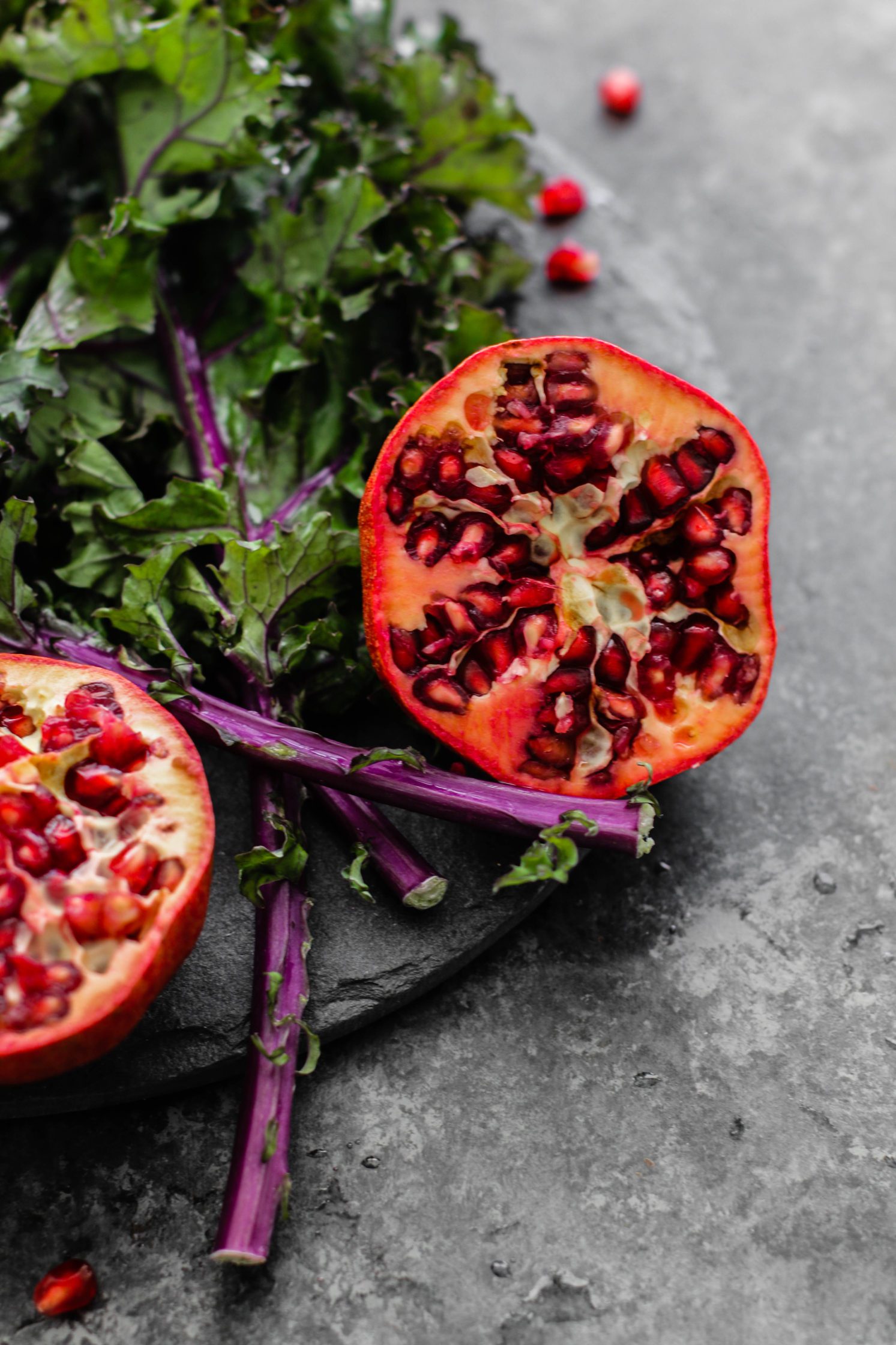 pomegranate and kale on cutting board by Flora & Vino 