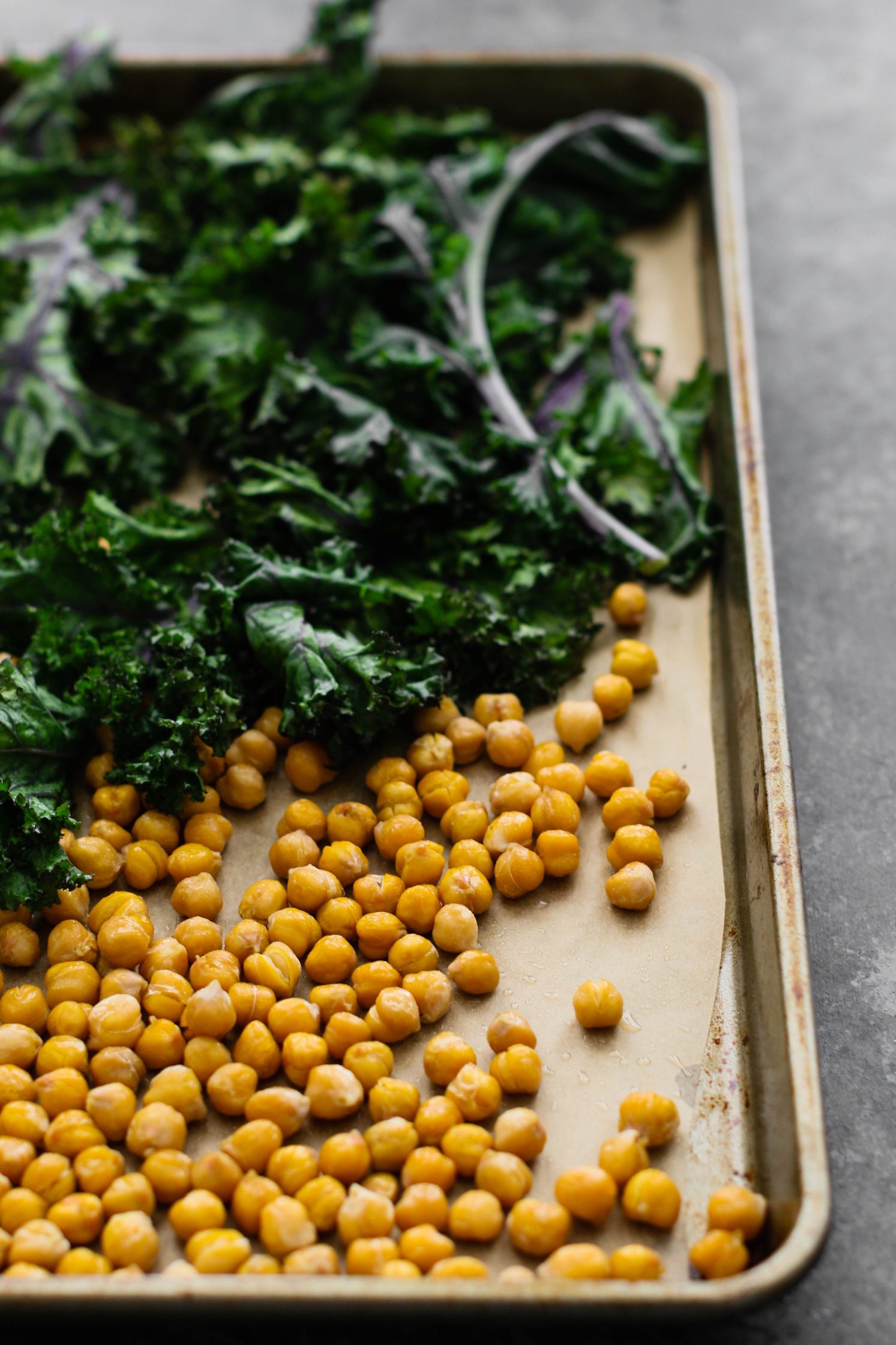 red kale and chickpeas on parchment lined baking sheet by Flora & Vino 
