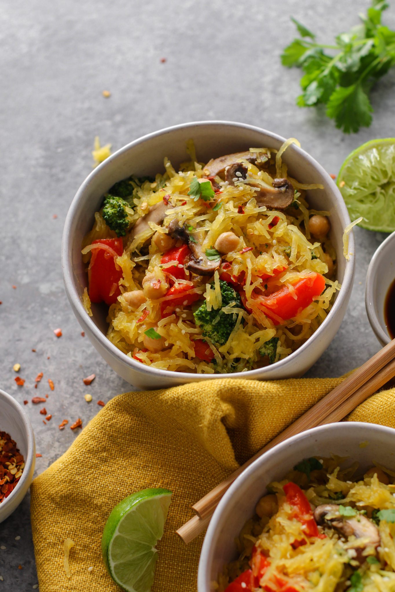 Spaghetti Squash Noodle Bowls with chopsticks, limes, cilantro, sesame, red pepper flakes, and soy sauce by Flora & Vino 