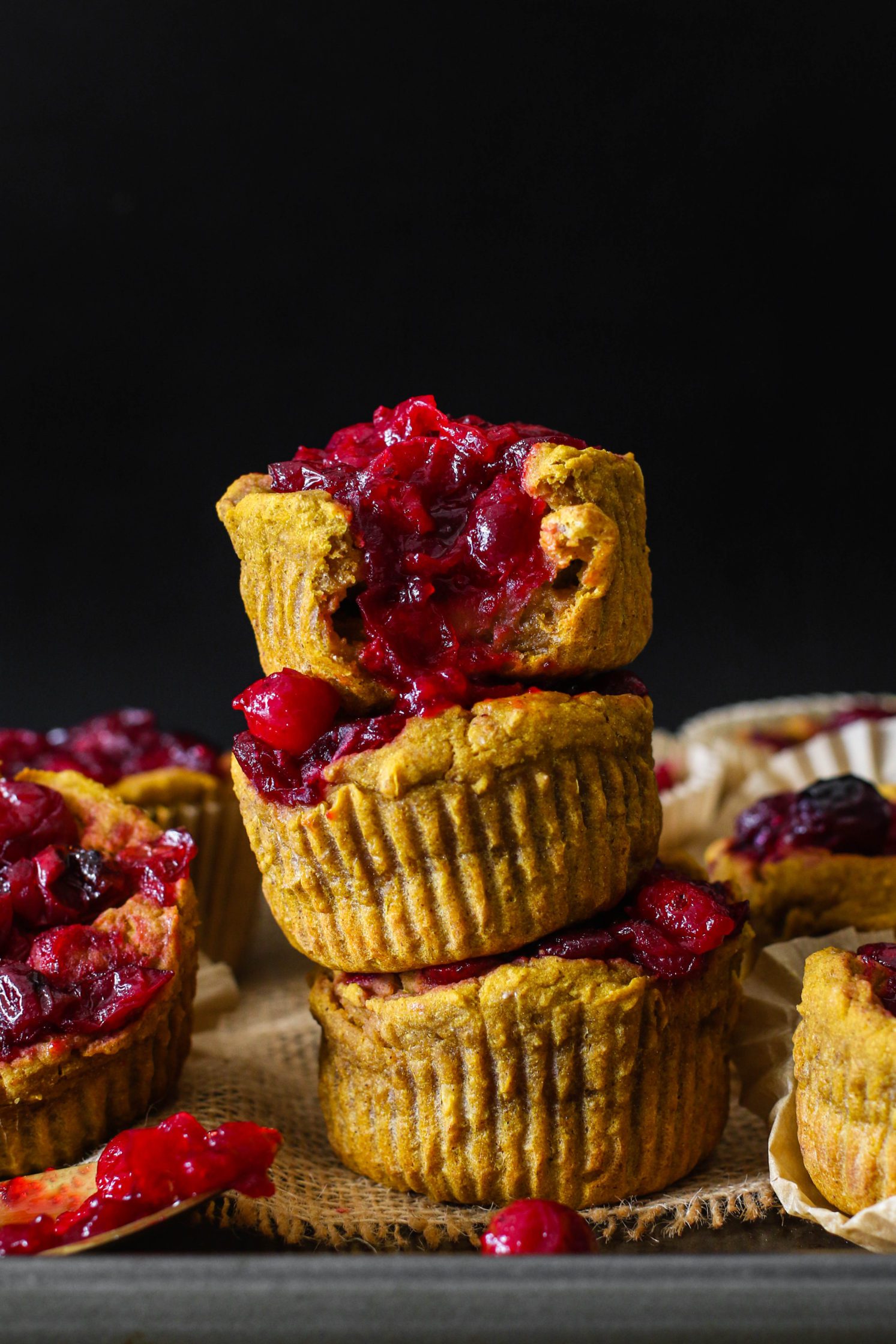 1-Bowl Kabocha Squash Cranberry Muffins stacked on baking sheet by Flora & Vino