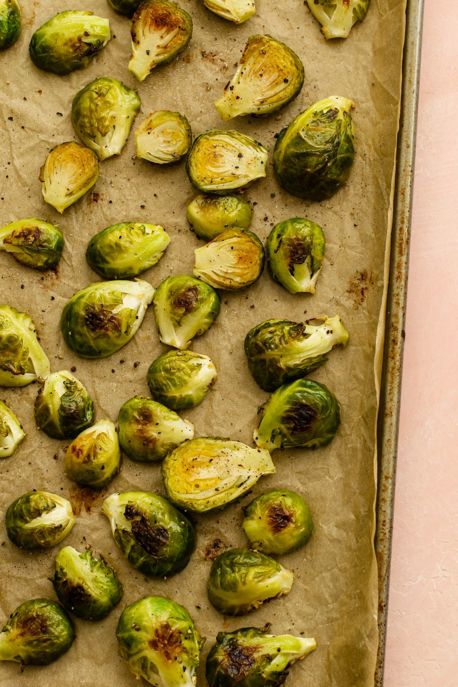 roasted brussels sprouts on parchment lined baking sheet by Flora & Vino