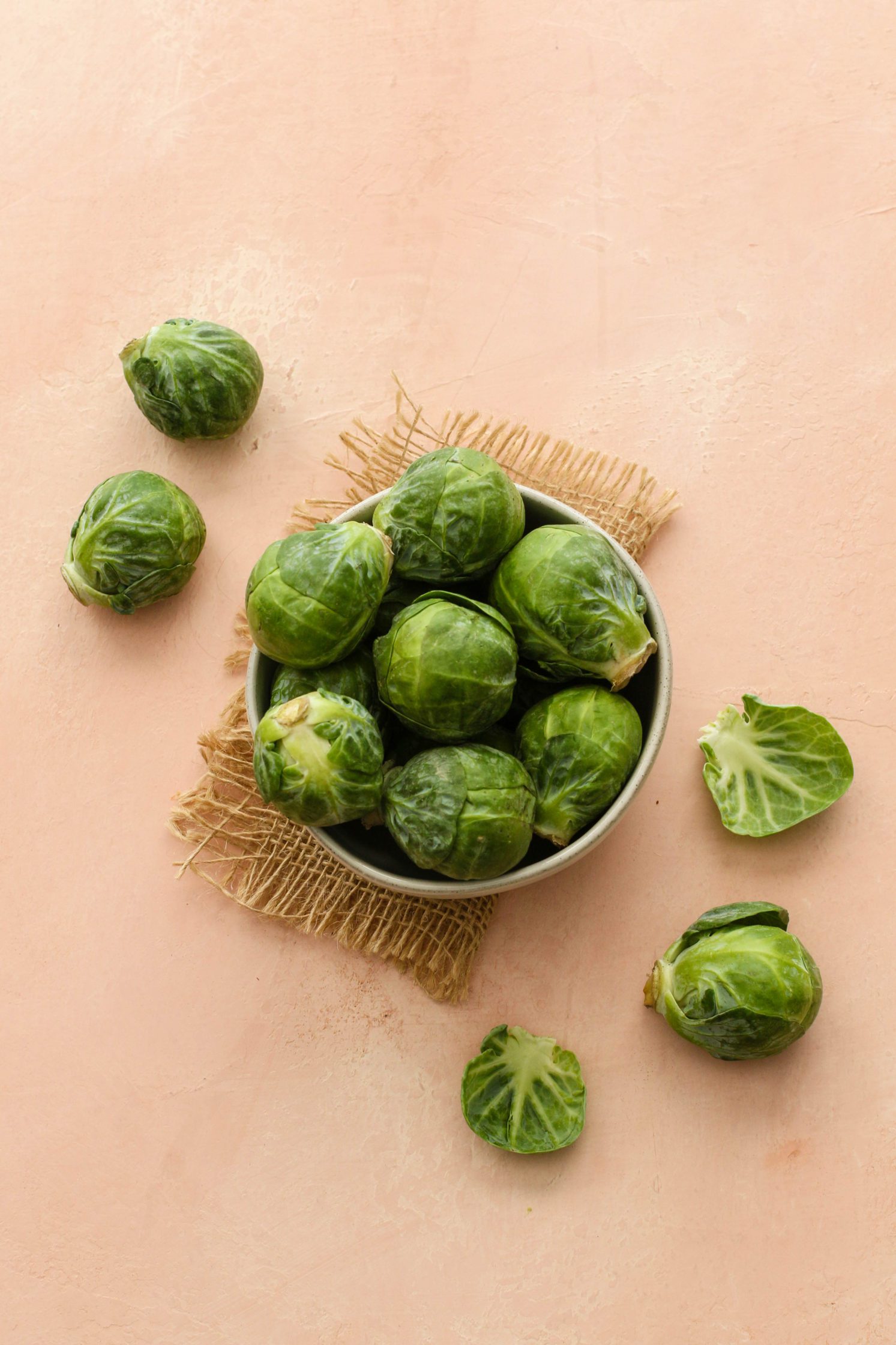 raw brussels sprouts in a bowl by Flora & Vino