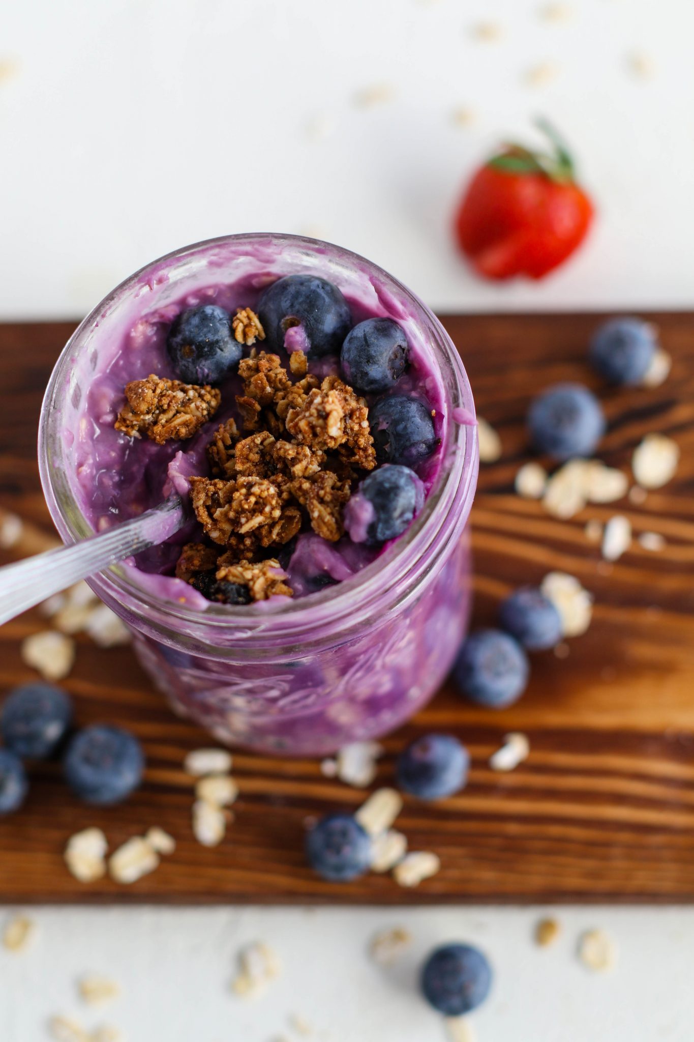 Purple Sweet Potato Overnight Oats served with berries and granola on wooden board by Flora & Vino