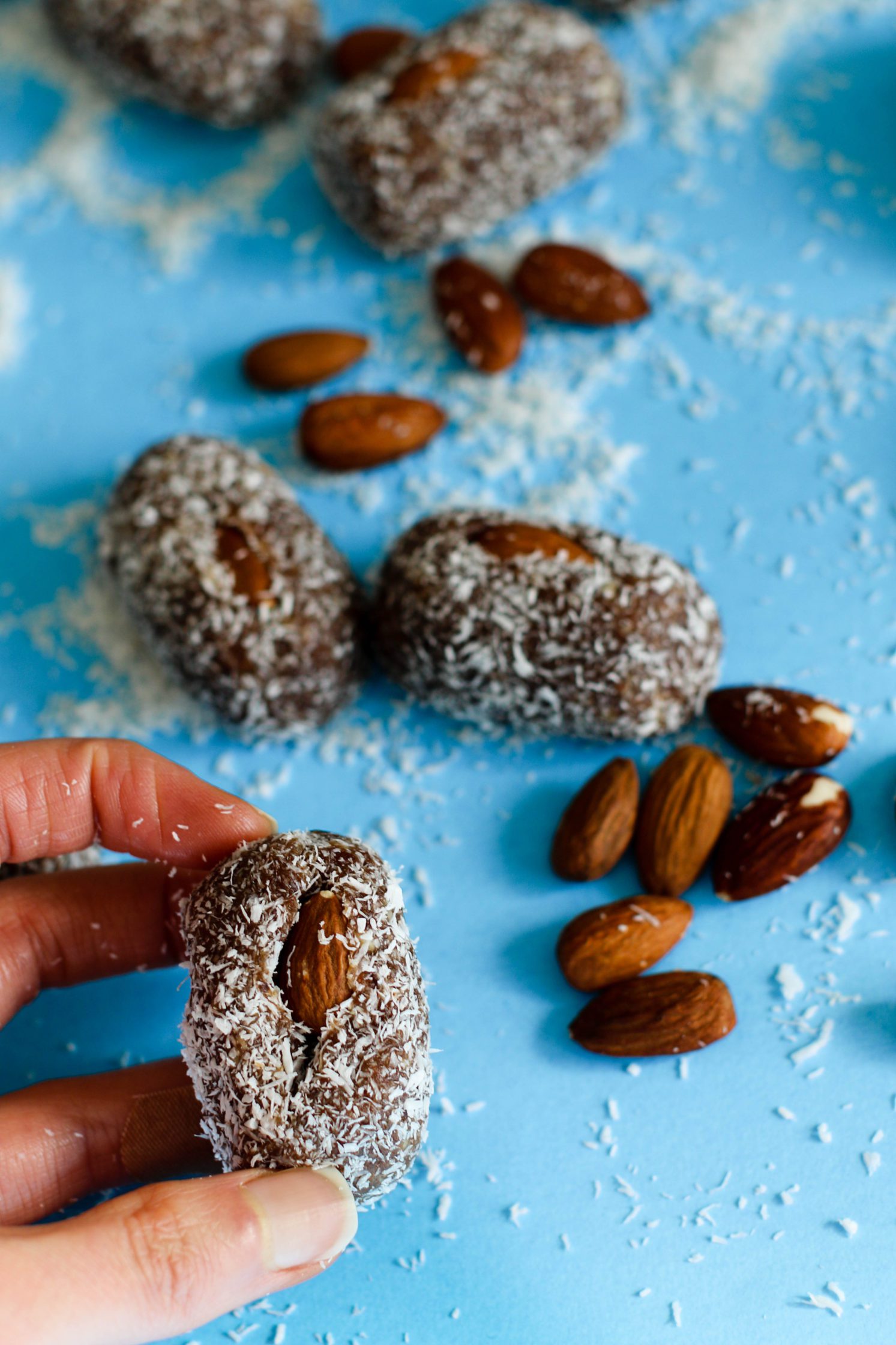 hand holding Coconut Almond Rolled Date by Flora & Vino