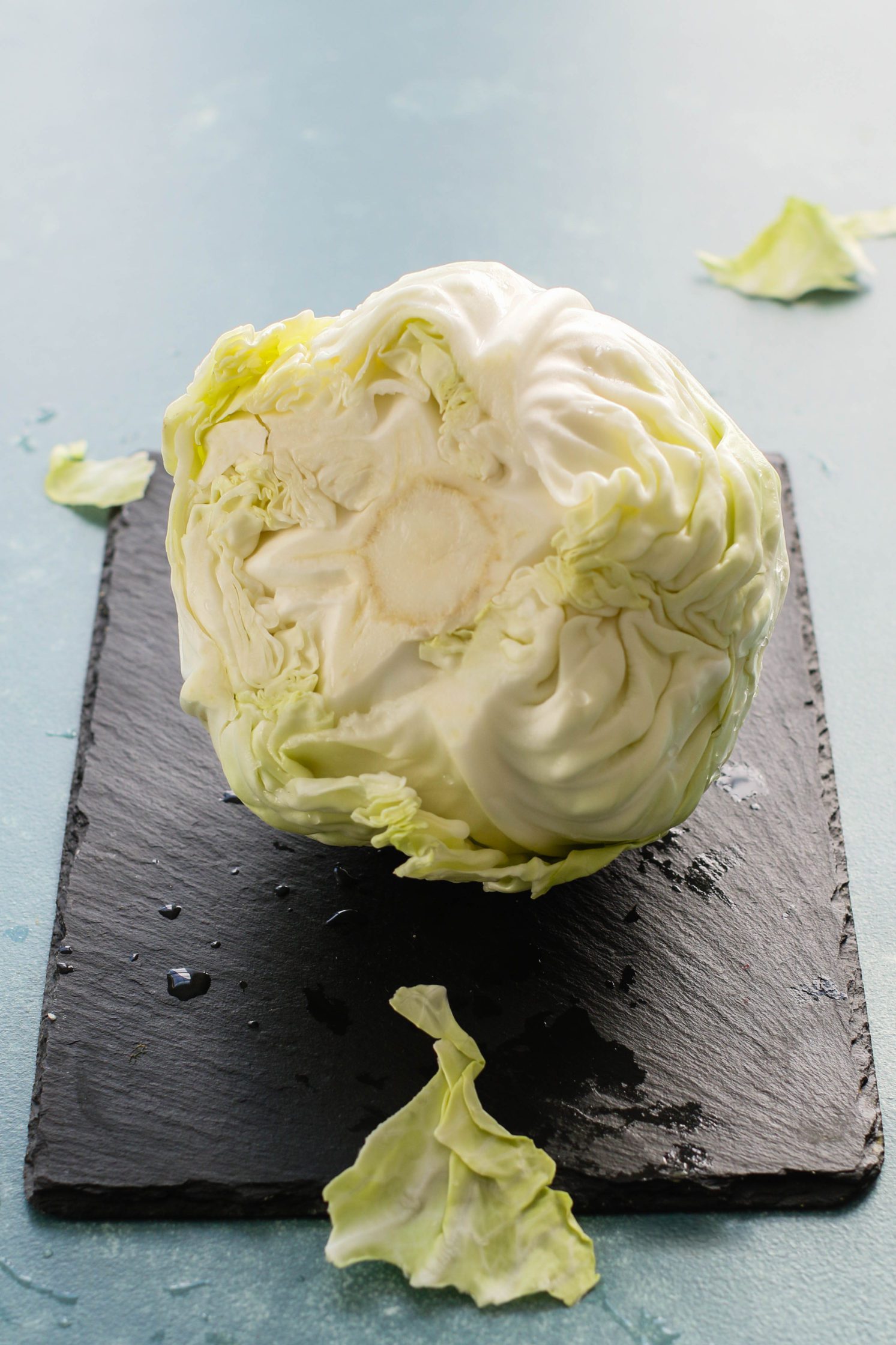 green cabbage on black cutting board