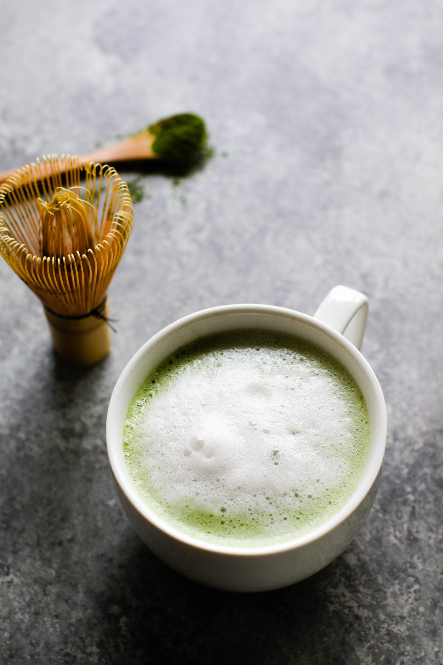 Cinnamon Almond Matcha Latte in mug with milk froth by Flora & Vino
