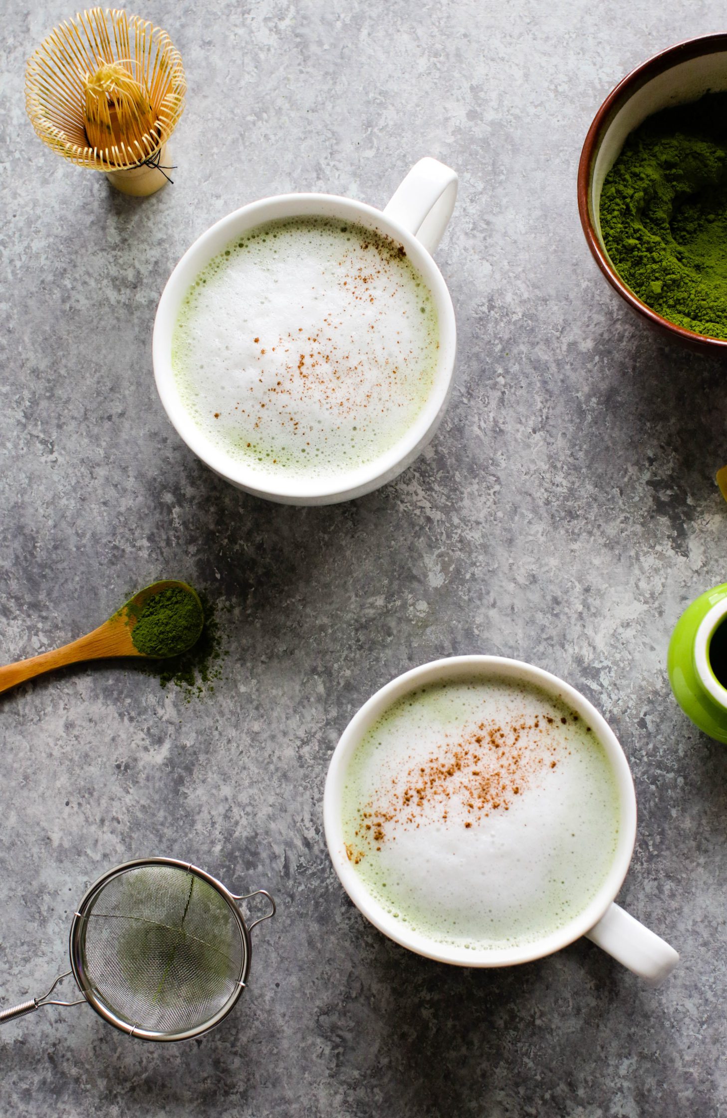 Cinnamon Almond Matcha Latte served in mugs with cinnamon sprinkled on top by Flora & Vino