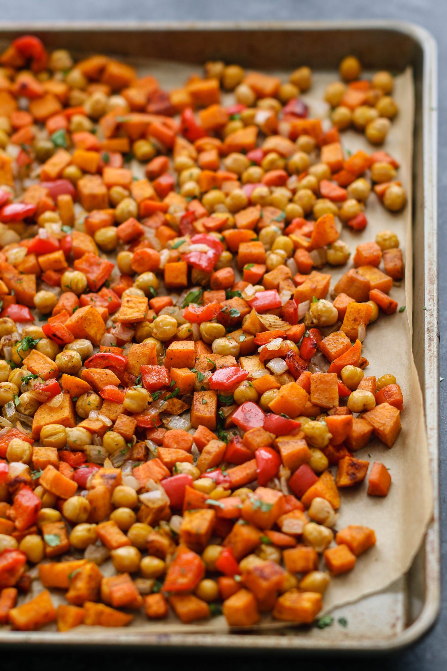 Warm Spiced Sweet Potato Salad with Pistachios on parchment lined baking sheet by Flora & Vino 