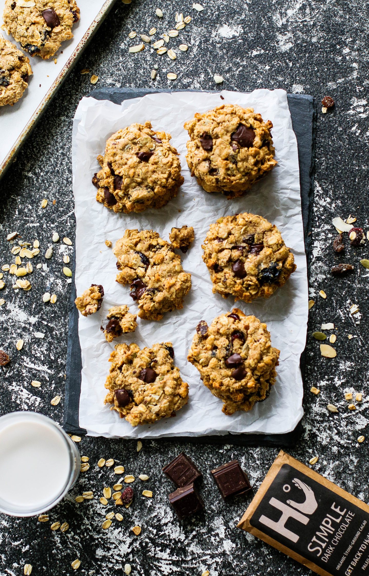 Chocolate Chunk Muesli Snack Cookies served on parchment paper on serving board with a glass of milk by Flora & Vino 
