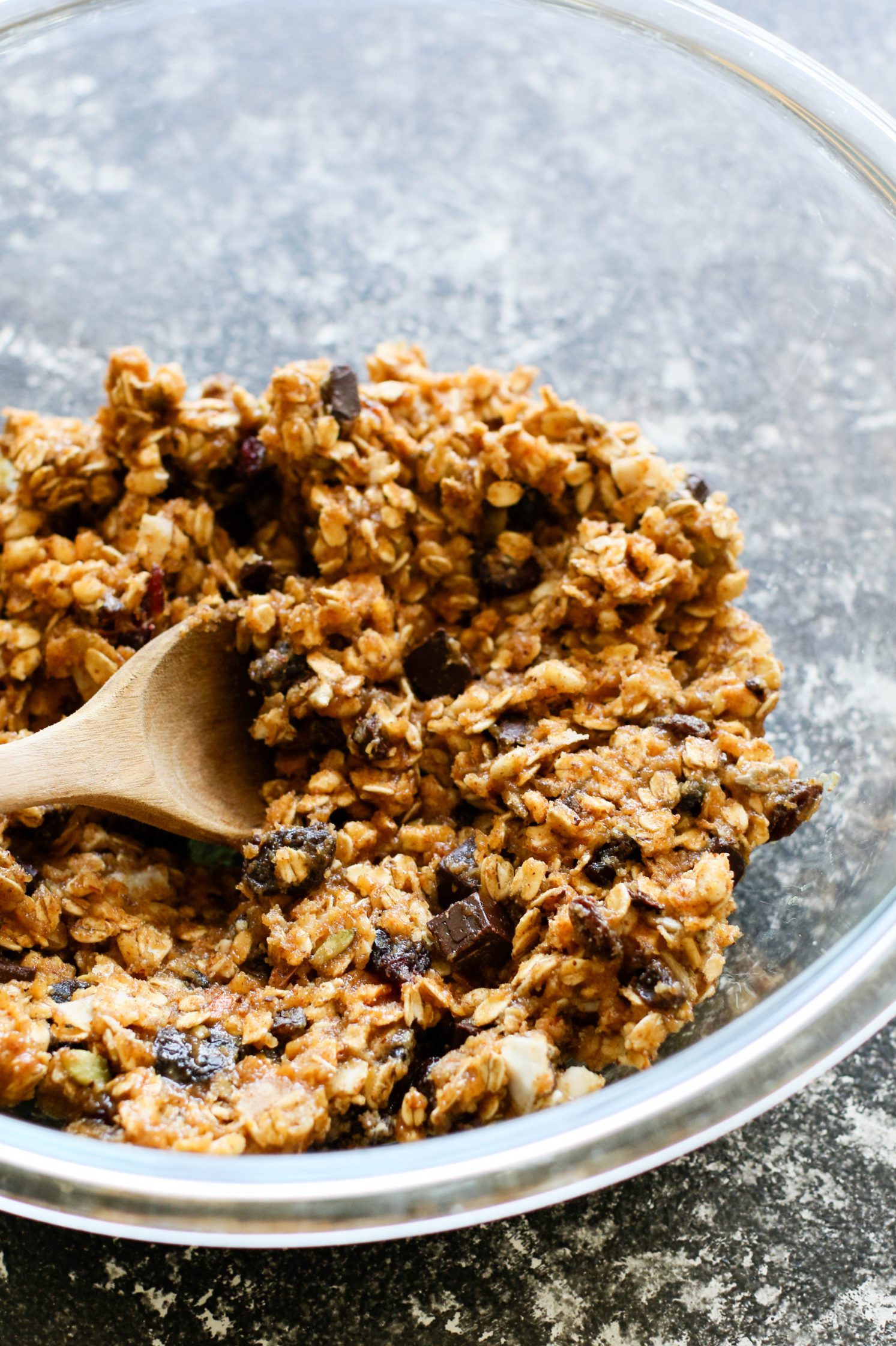 Chocolate Chunk Muesli Snack Cookie batter in bowl with wooden spoon by Flora & Vino