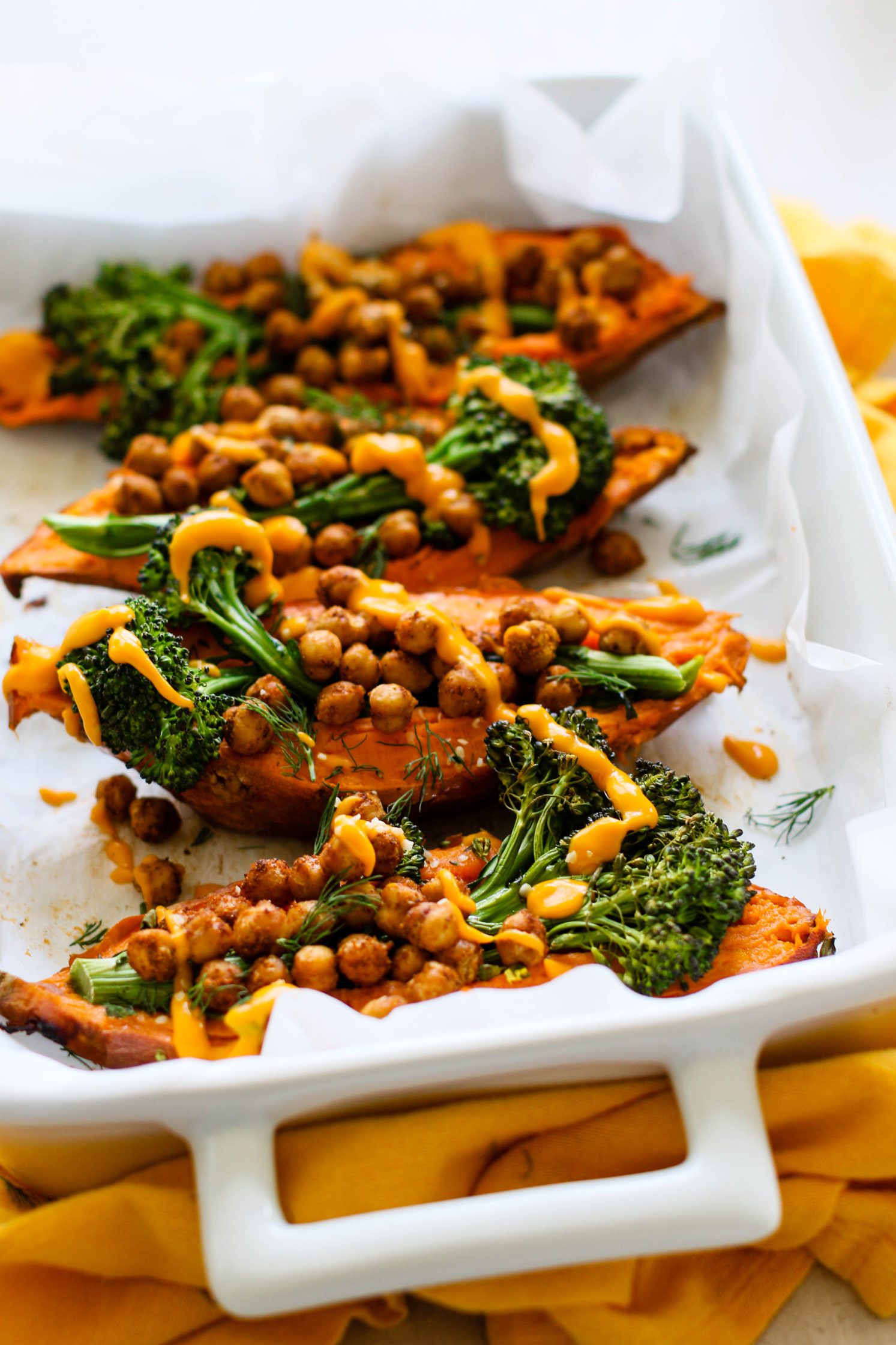 Sweet Potato Boats with Baby Broccoli & Ginger Turmeric Sweet Potato Cream in parchment lined baking pan by Flora & Vino 
