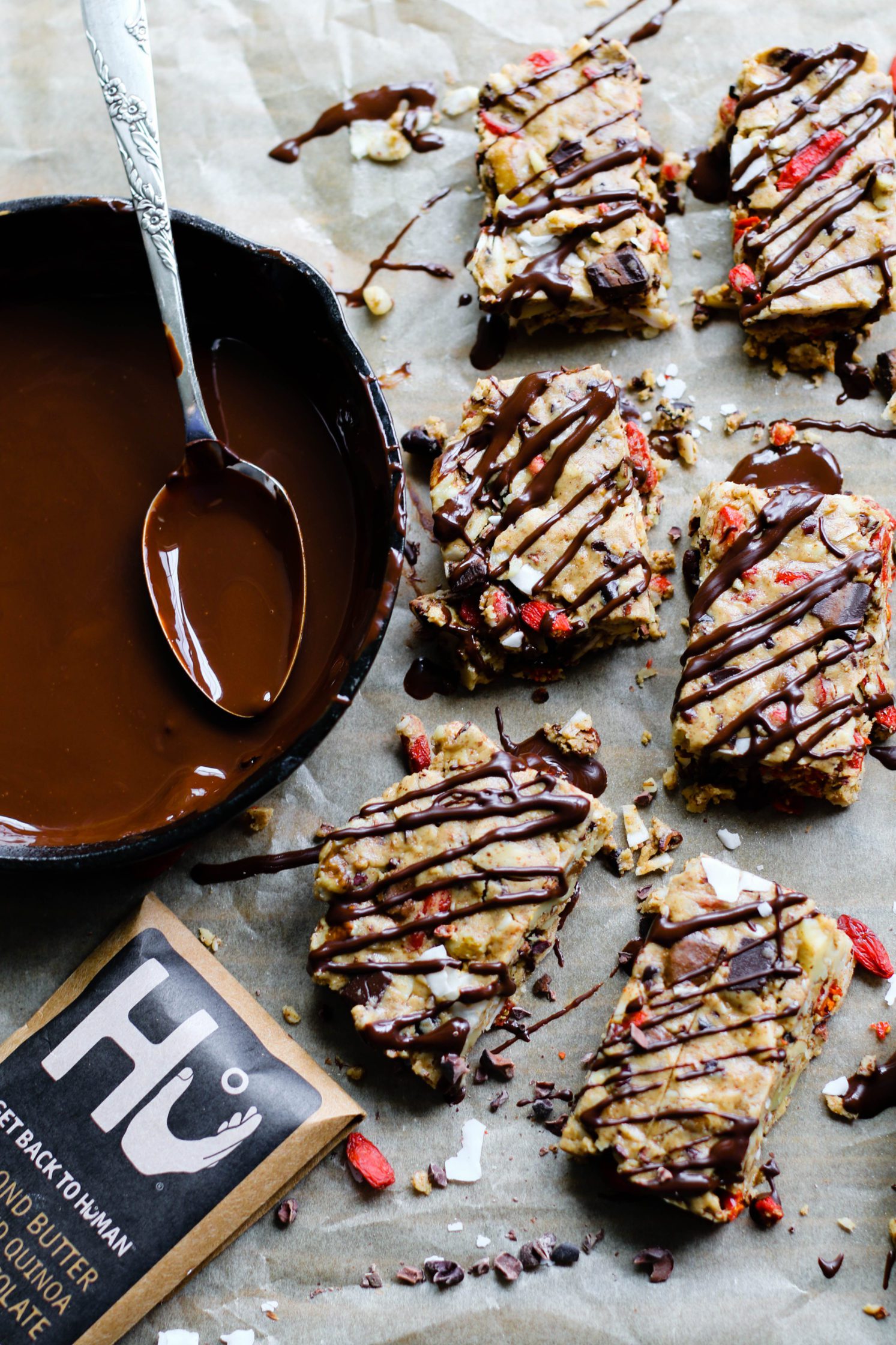 Raw Almond Butter Superfood Bars sliced into bars with pan of dark chocolate melted with a spoon by Flora & Vino