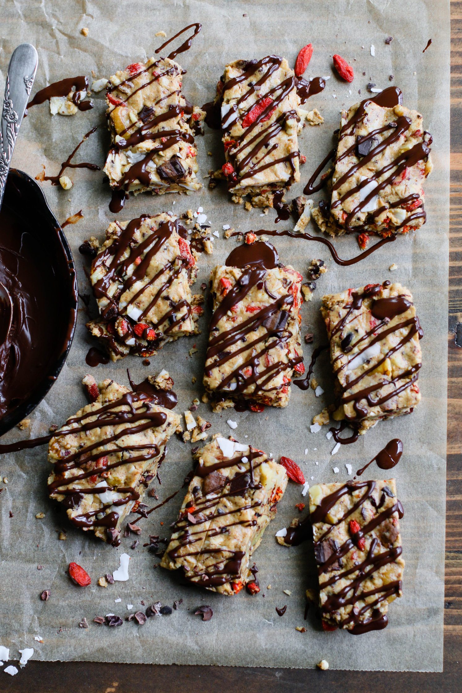 Raw Almond Butter Superfood Bars drizzled with dark chocolate on parchment paper by Flora & Vino