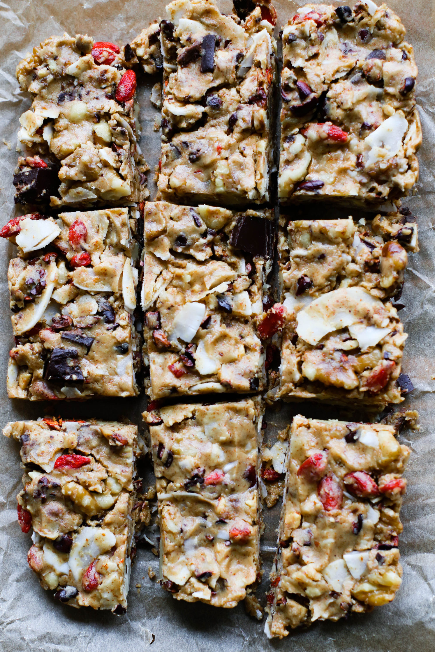 Raw Almond Butter Superfood Bars sliced into bars on parchment paper by Flora & Vino