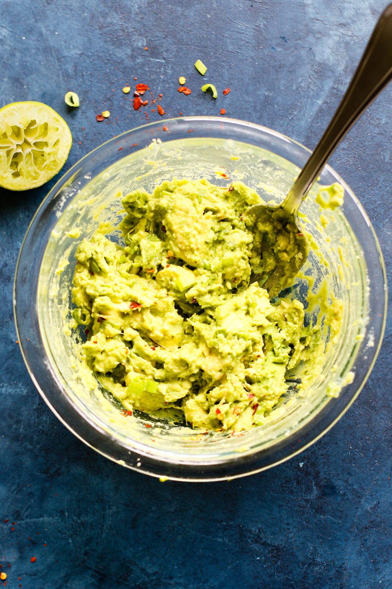 Perfect 5-Ingredient Guacamole smashed in bowl with spoon by Flora & Vino