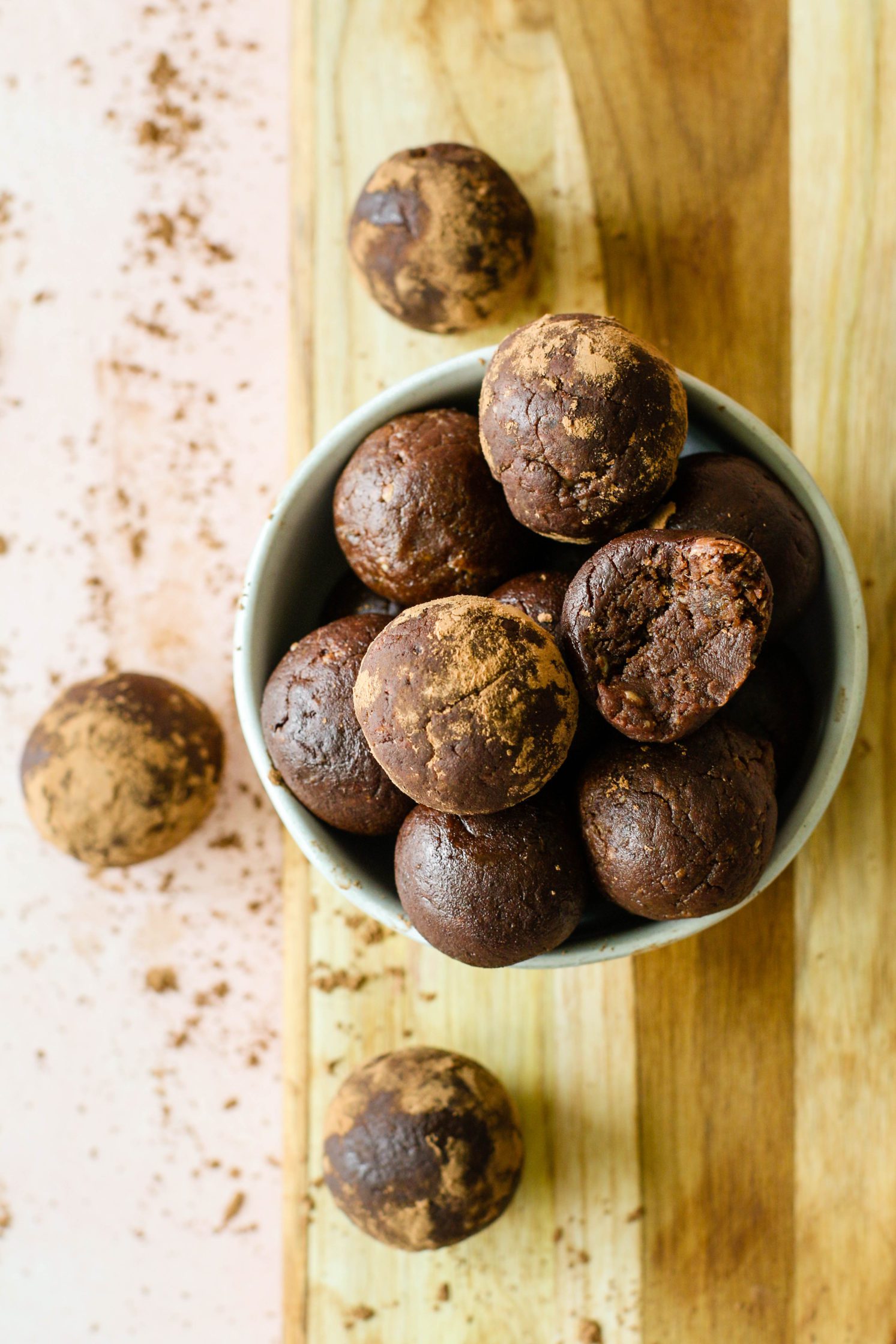 Beet Brownie Bliss Balls served in a bowl on a wooden board by Flora & Vino