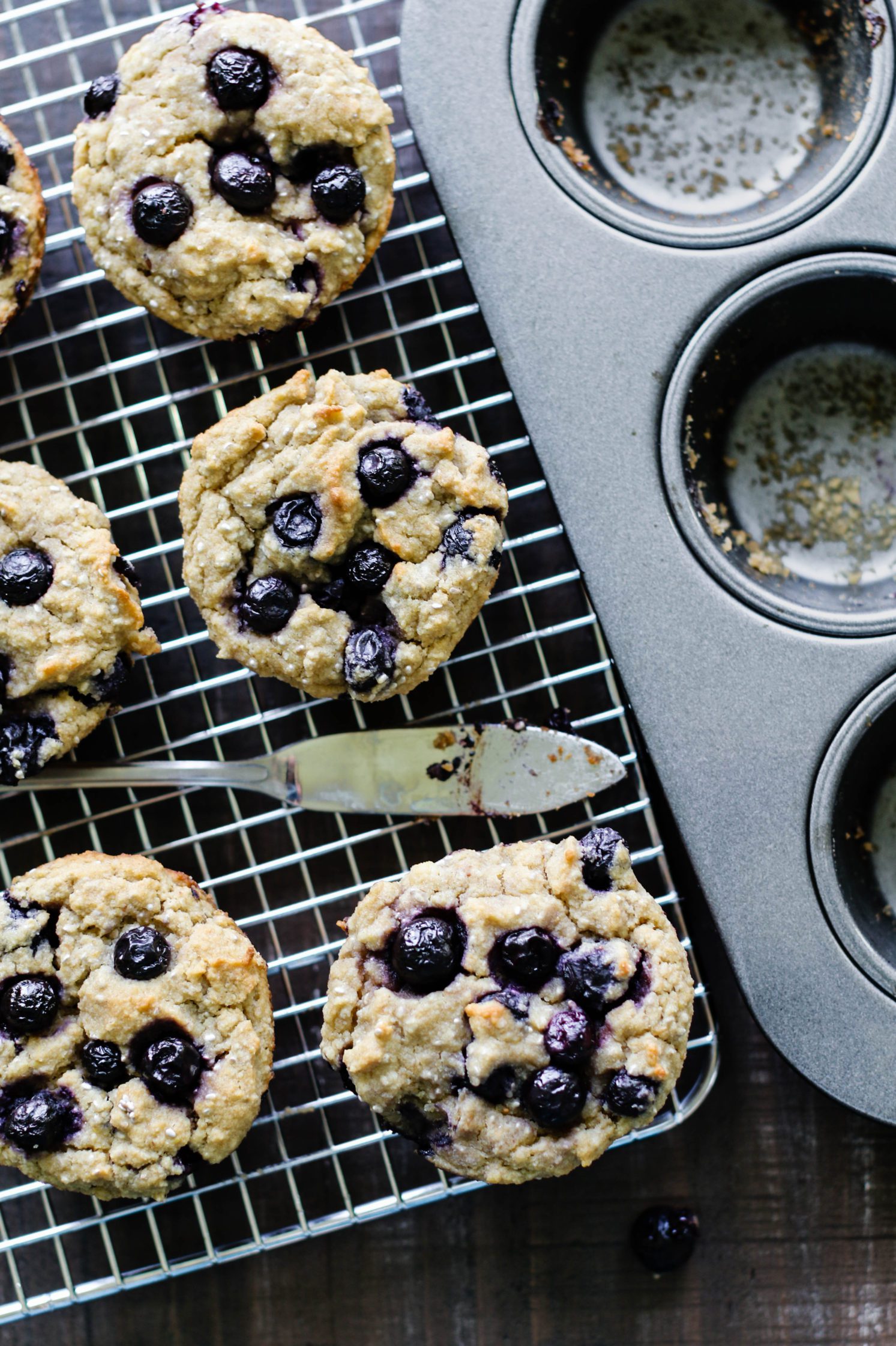 The Best Vegan & Gluten Free Blueberry Muffins baked on cooling rack with knife