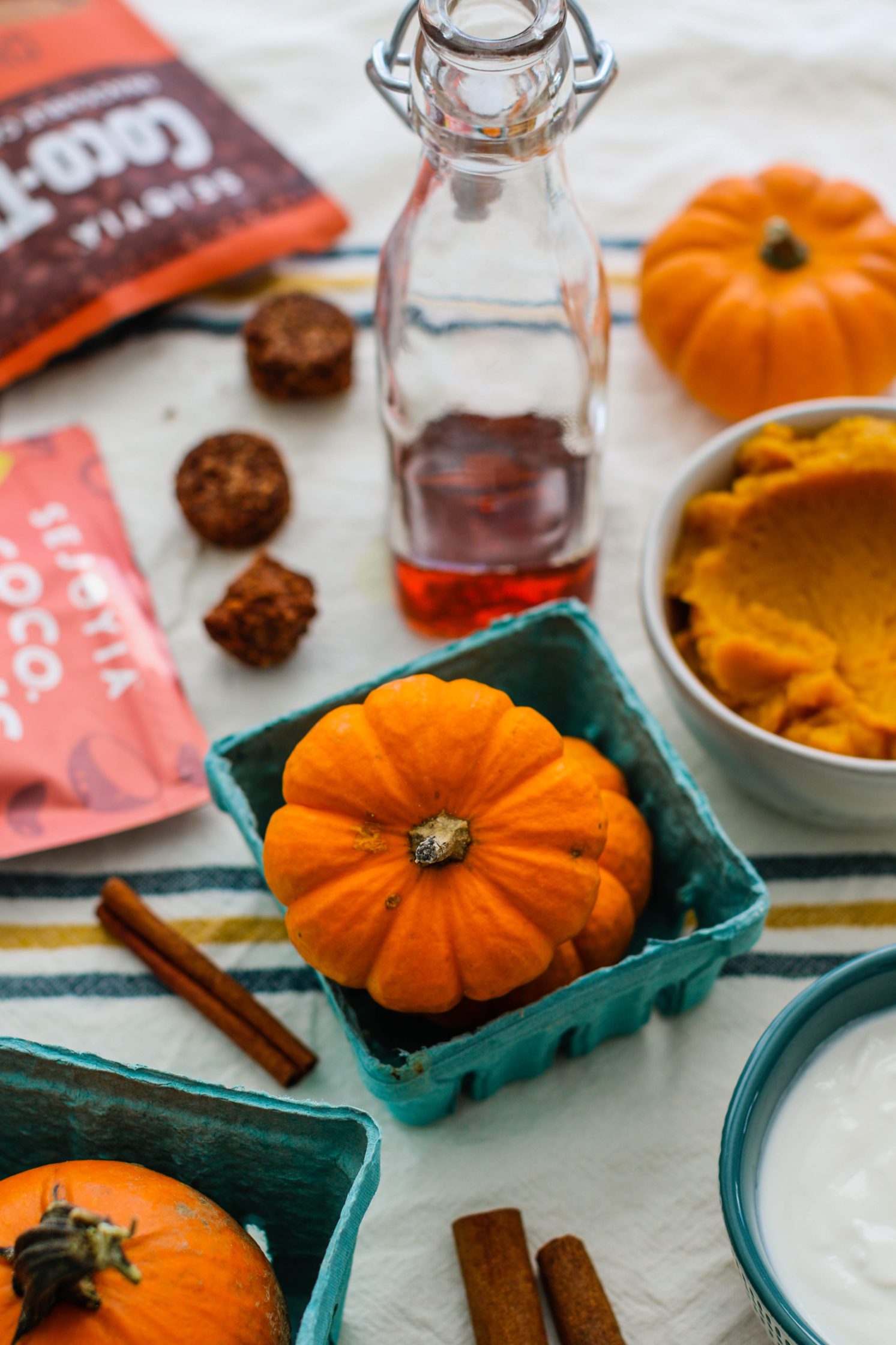 pumpkins, cookies, and maple syrup on towel by Flora & Vino