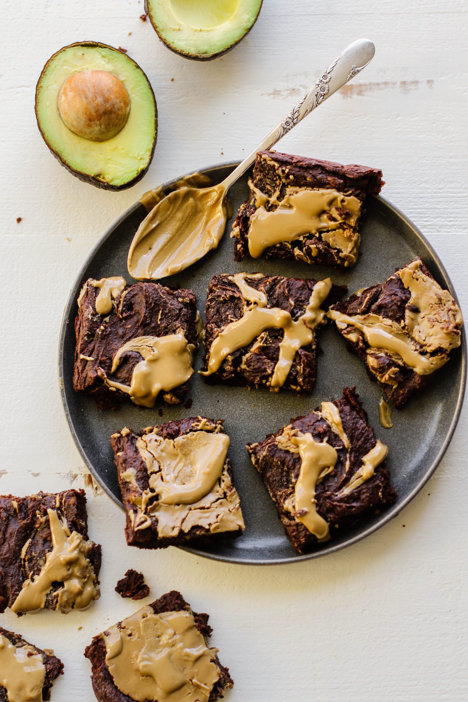 Avocado SunButter Swirl Brownies served on a plate with a spoonful of SunButter with avocados on the side