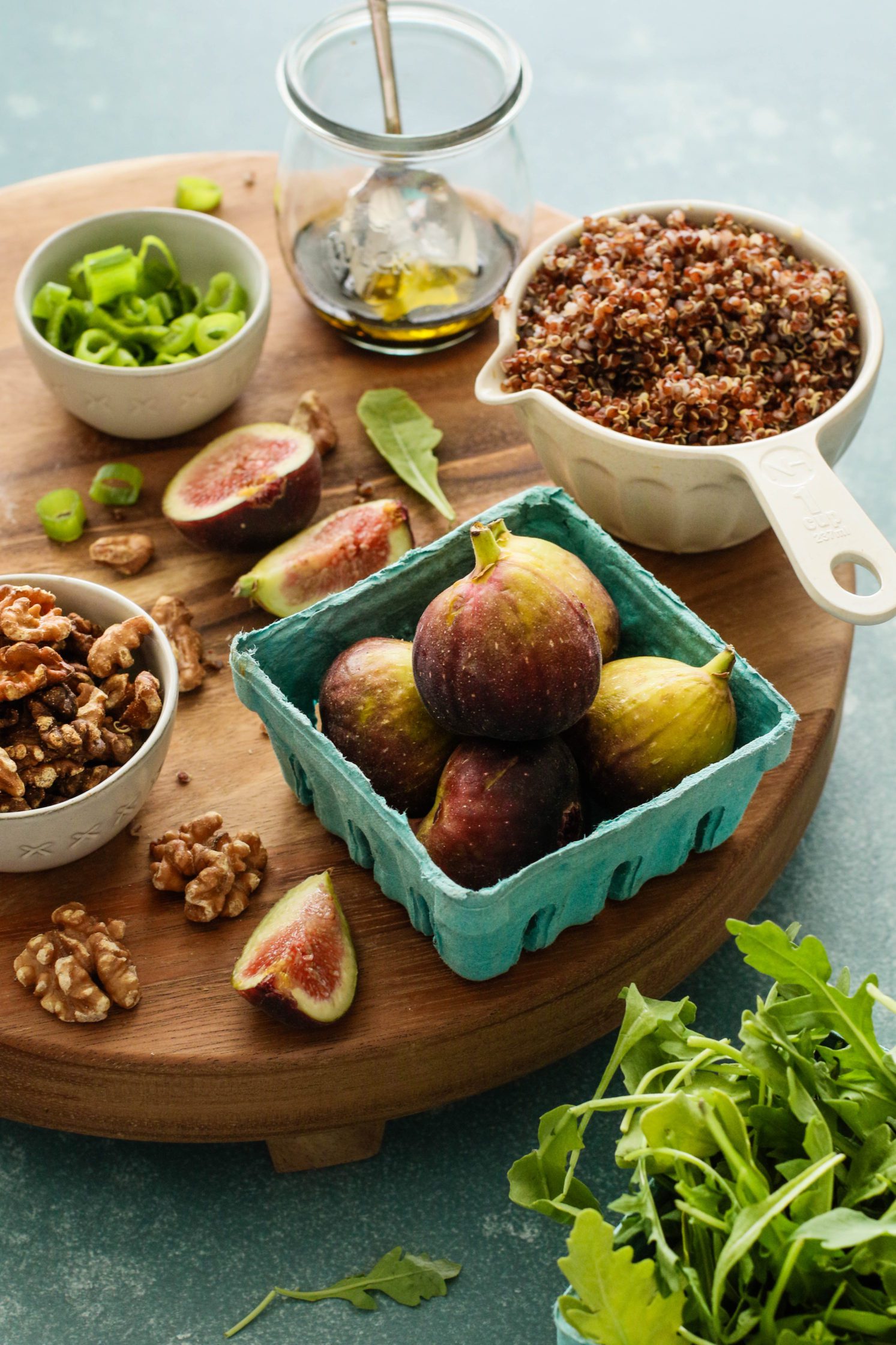 figs, quinoa, walnuts, and green onion on a serving board by Flora & Vino