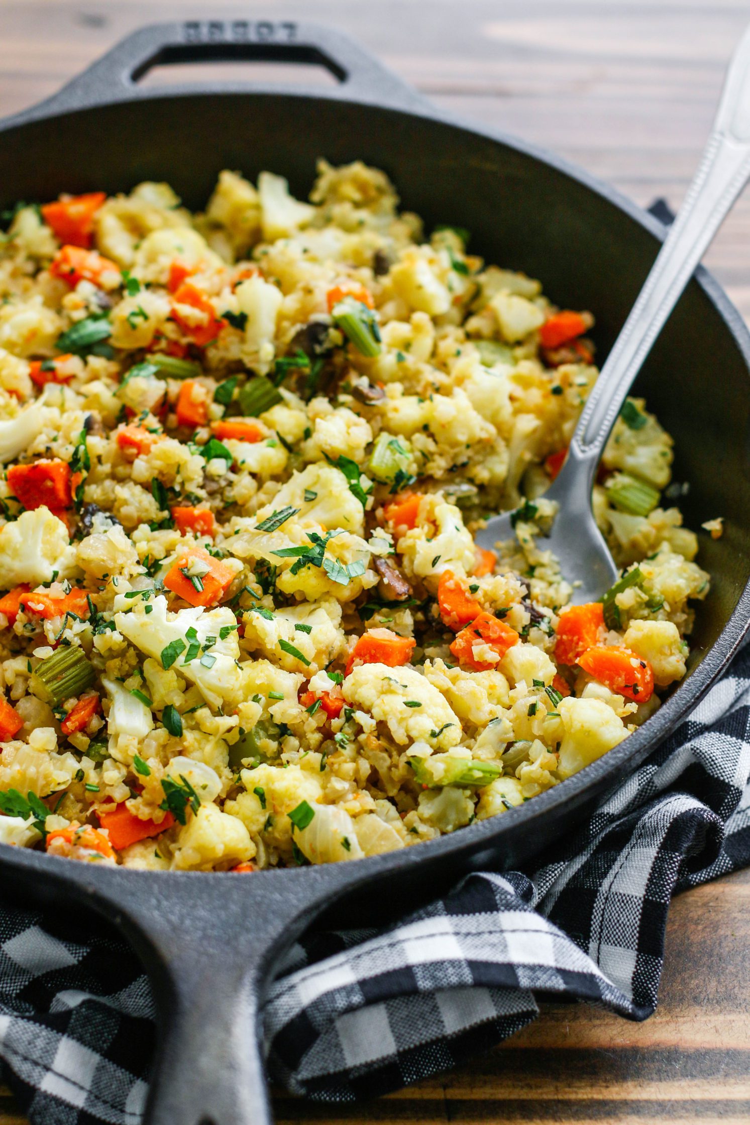 Stovetop Cauliflower Rice Stuffing with cast iron skillet with spoon by Flora & Vino