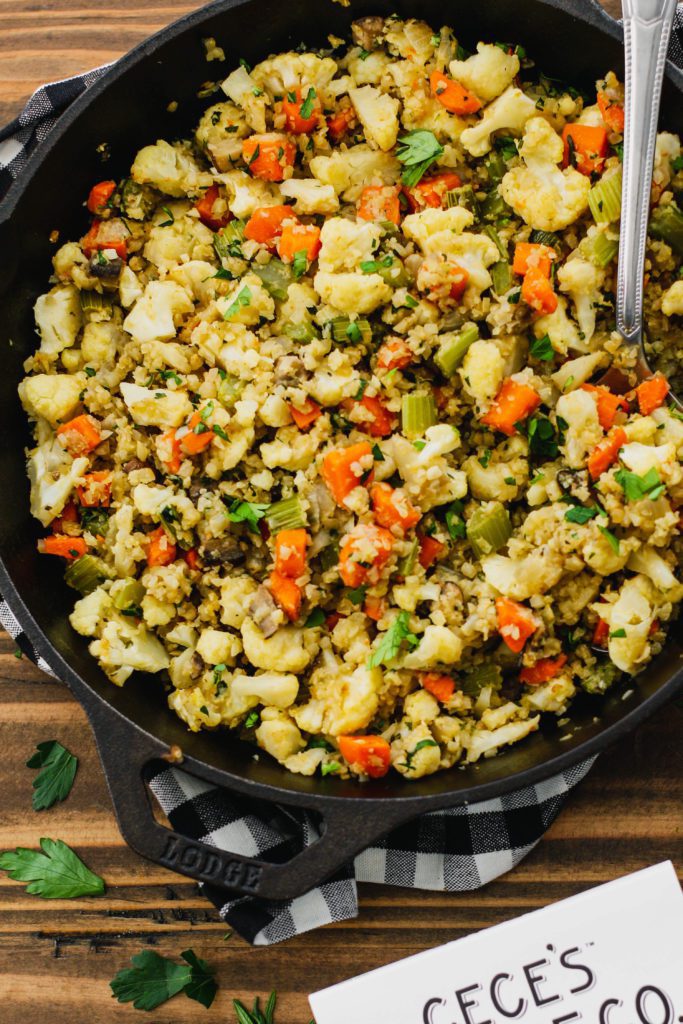 Stovetop Cauliflower Rice Stuffing with cast iron skillet with spoon by Flora & Vino