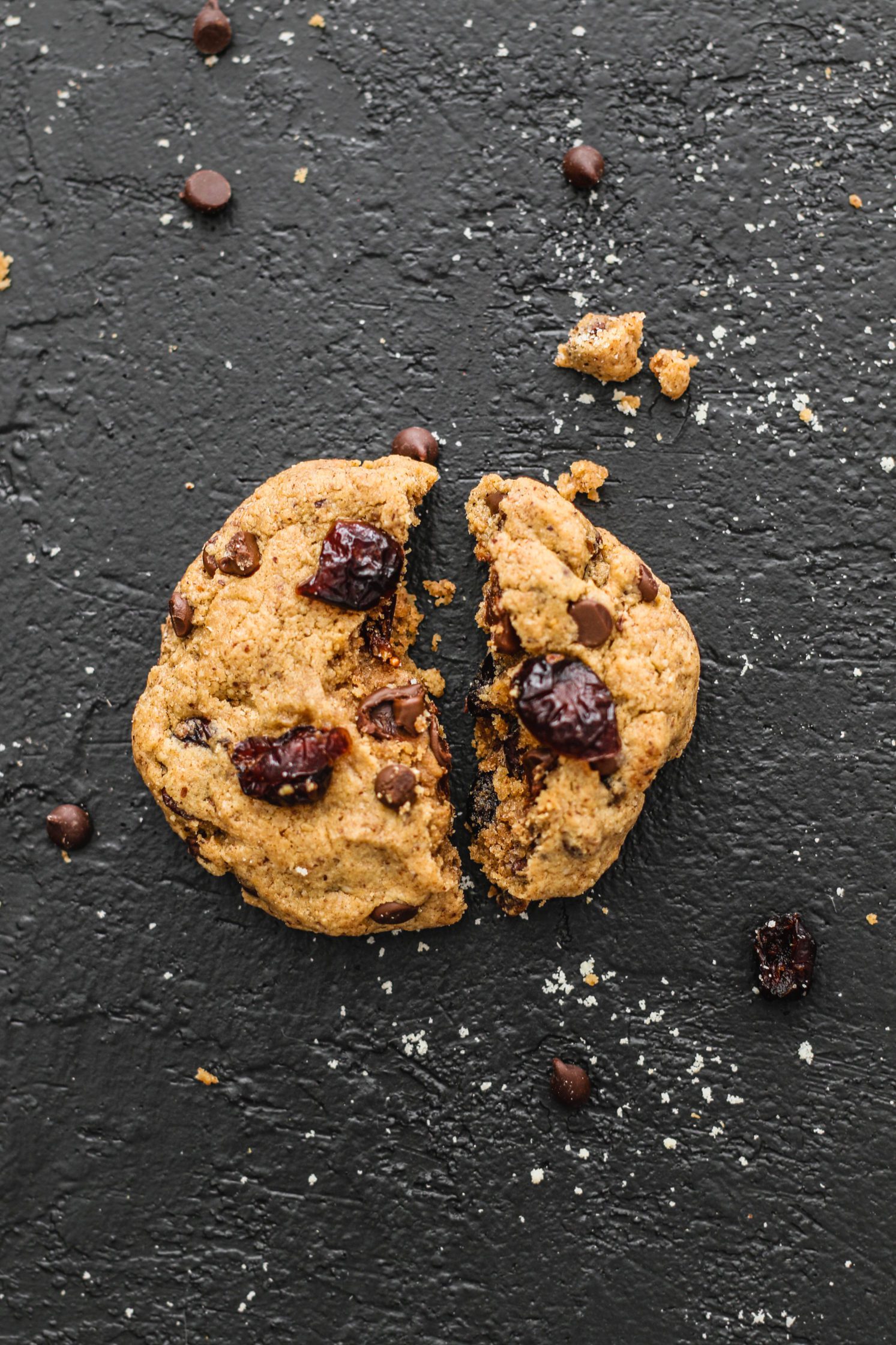Flourless Cranberry Chocolate Chip Cookie broken in half by Flora & Vino