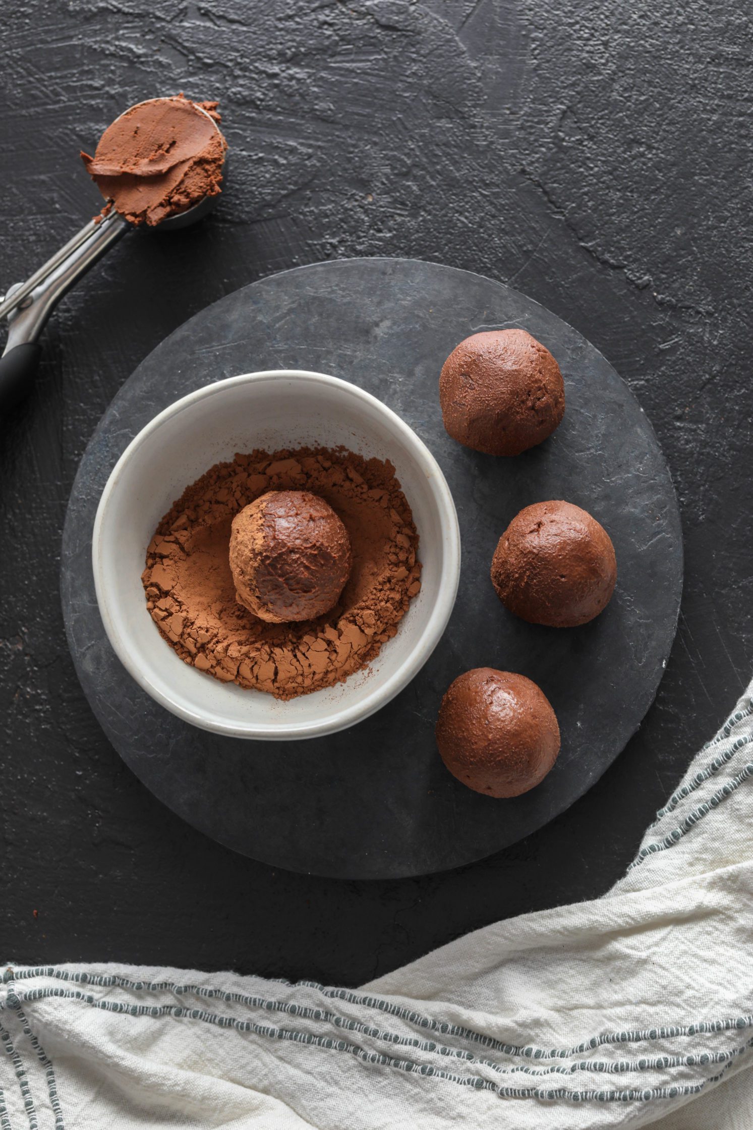 Cacao Dusted Dark Chocolate Truffles rolled in bowl of cacao