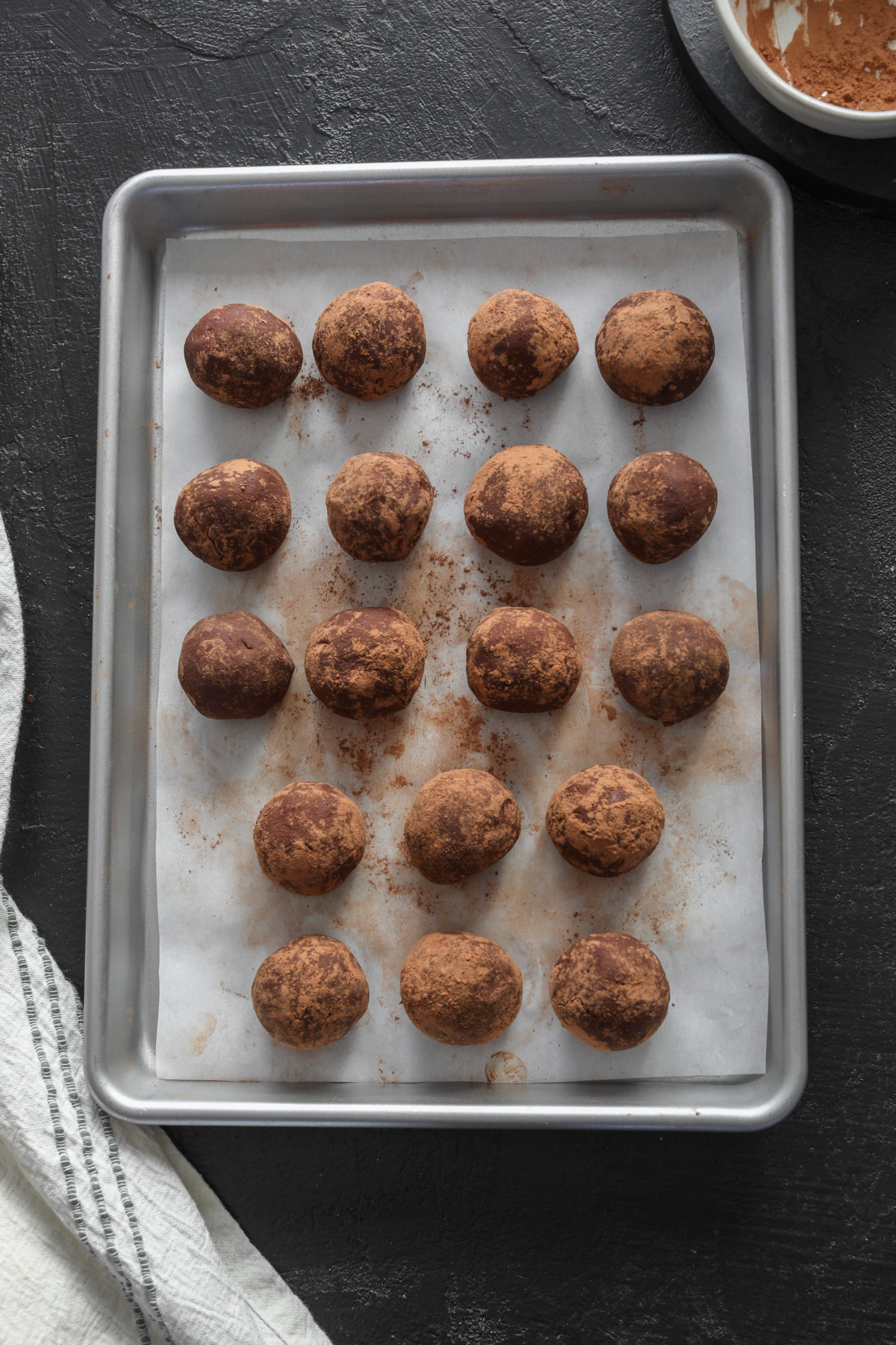 Cacao Dusted Dark Chocolate Truffles on parchment lined pan by Flora & Vino 