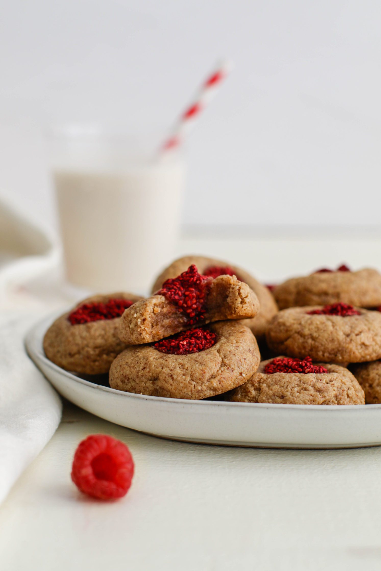 Raspberry-Beet Almond Flour Thumbprint Cookies served on a palte with bite out of one by Flora & Vino