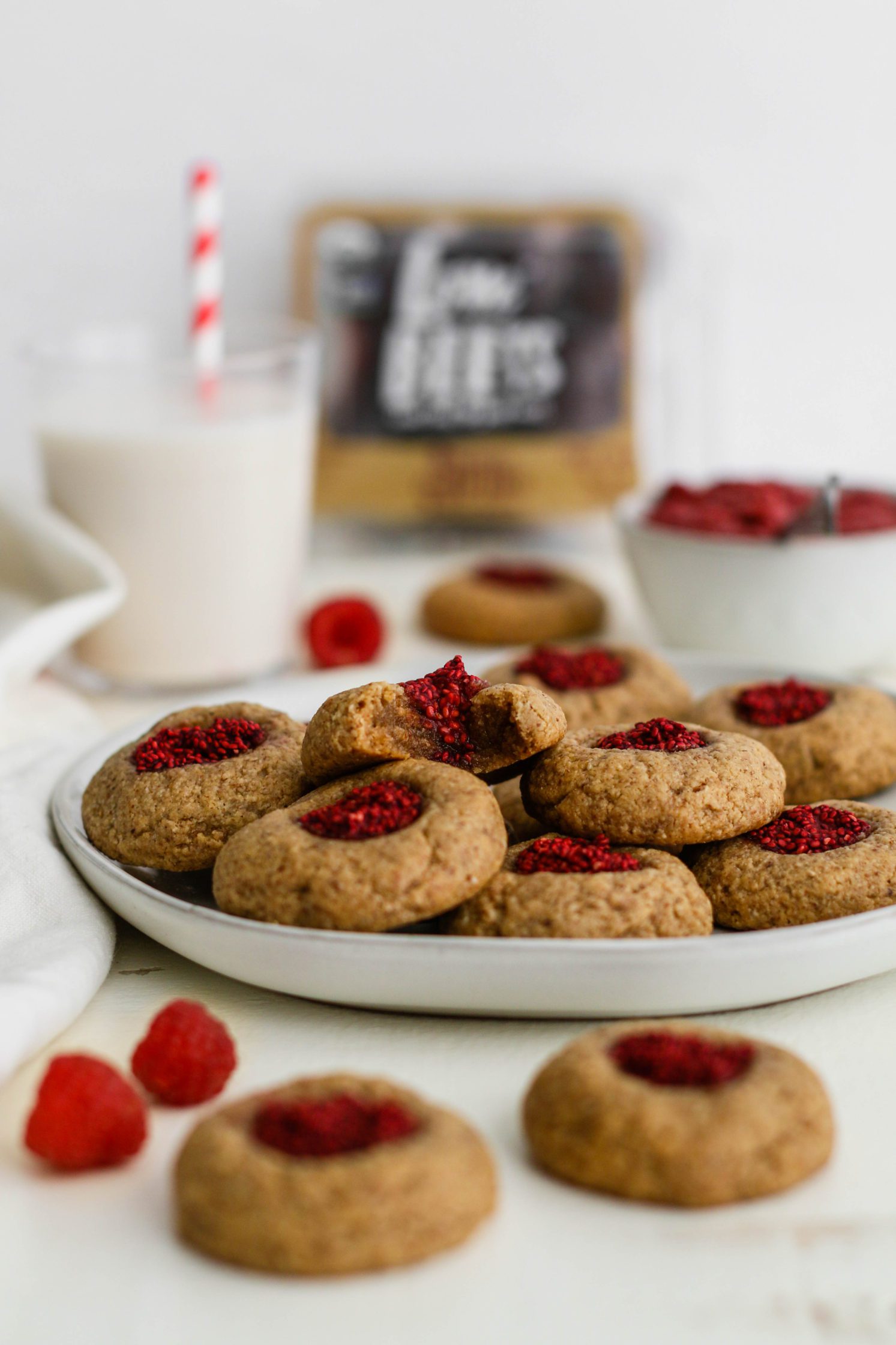 plate of Raspberry-Beet Almond Flour Thumbprint Cookies with bite out of one by Flora & Vino