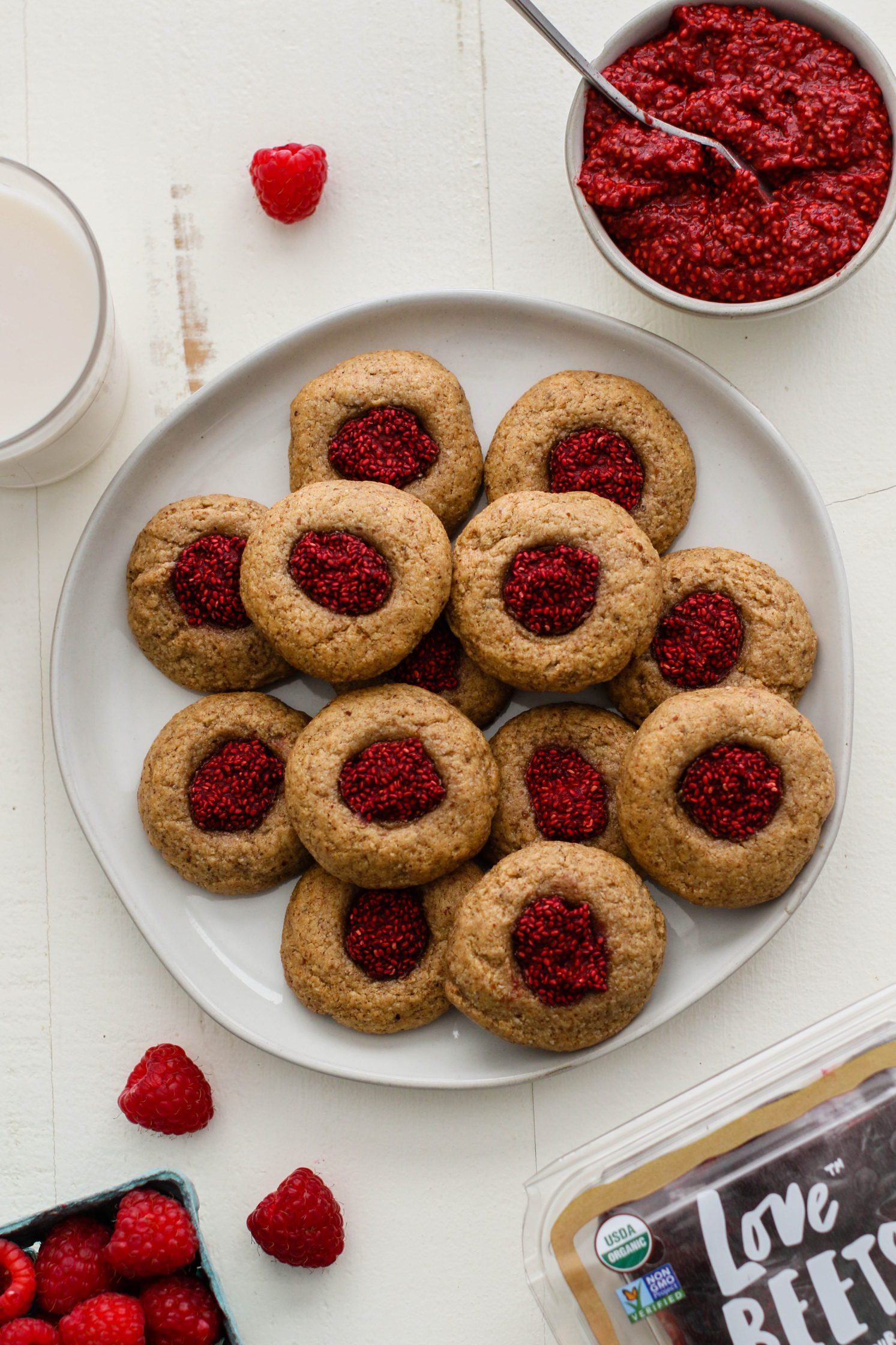 Raspberry-Beet Almond Flour Thumbprint Cookies served on a plate with a side of raspberry-beet jam by Flora & Vino