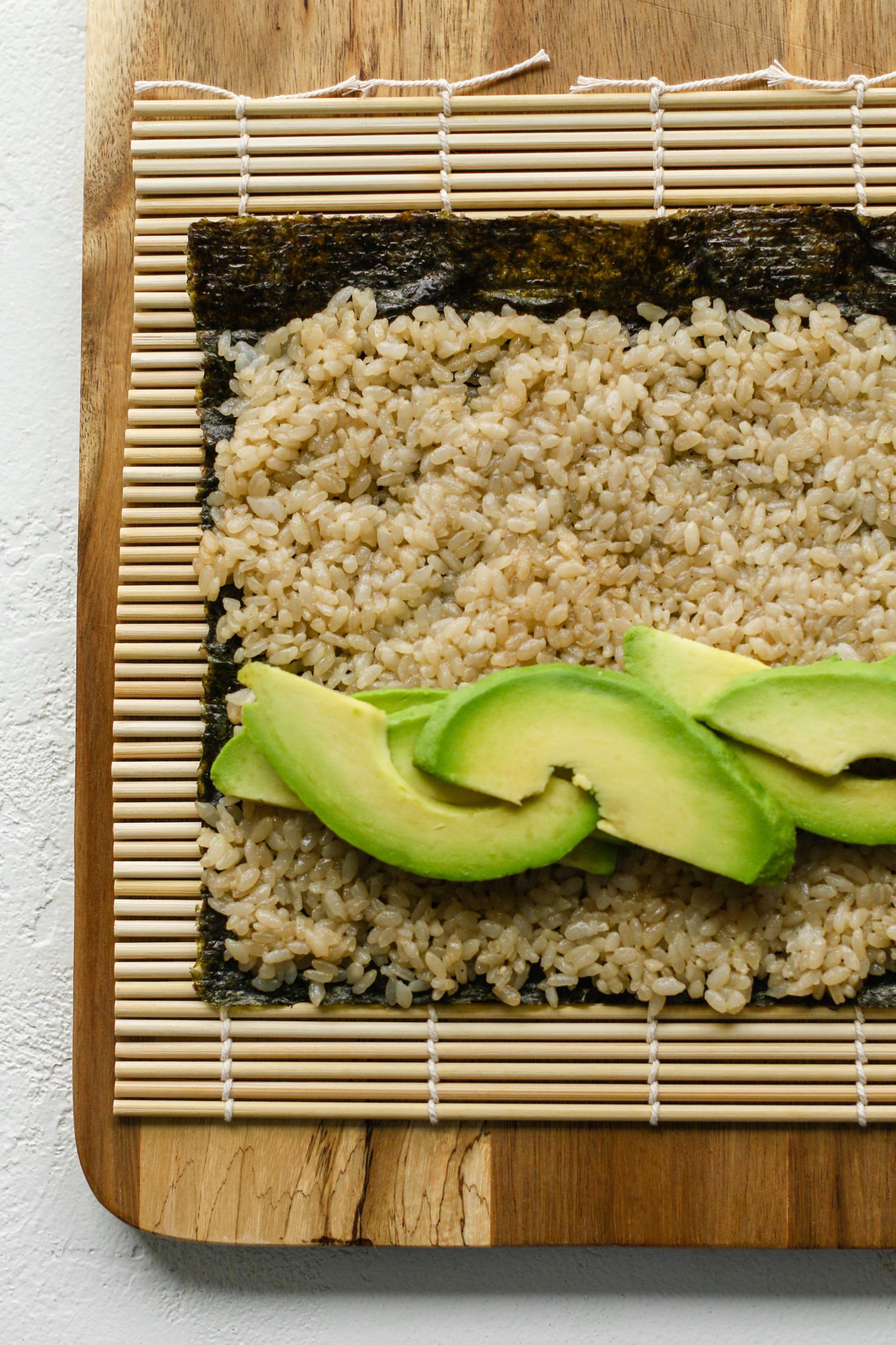 vegan sushi being rolled with sushi rice and avocado by Flora & Vino