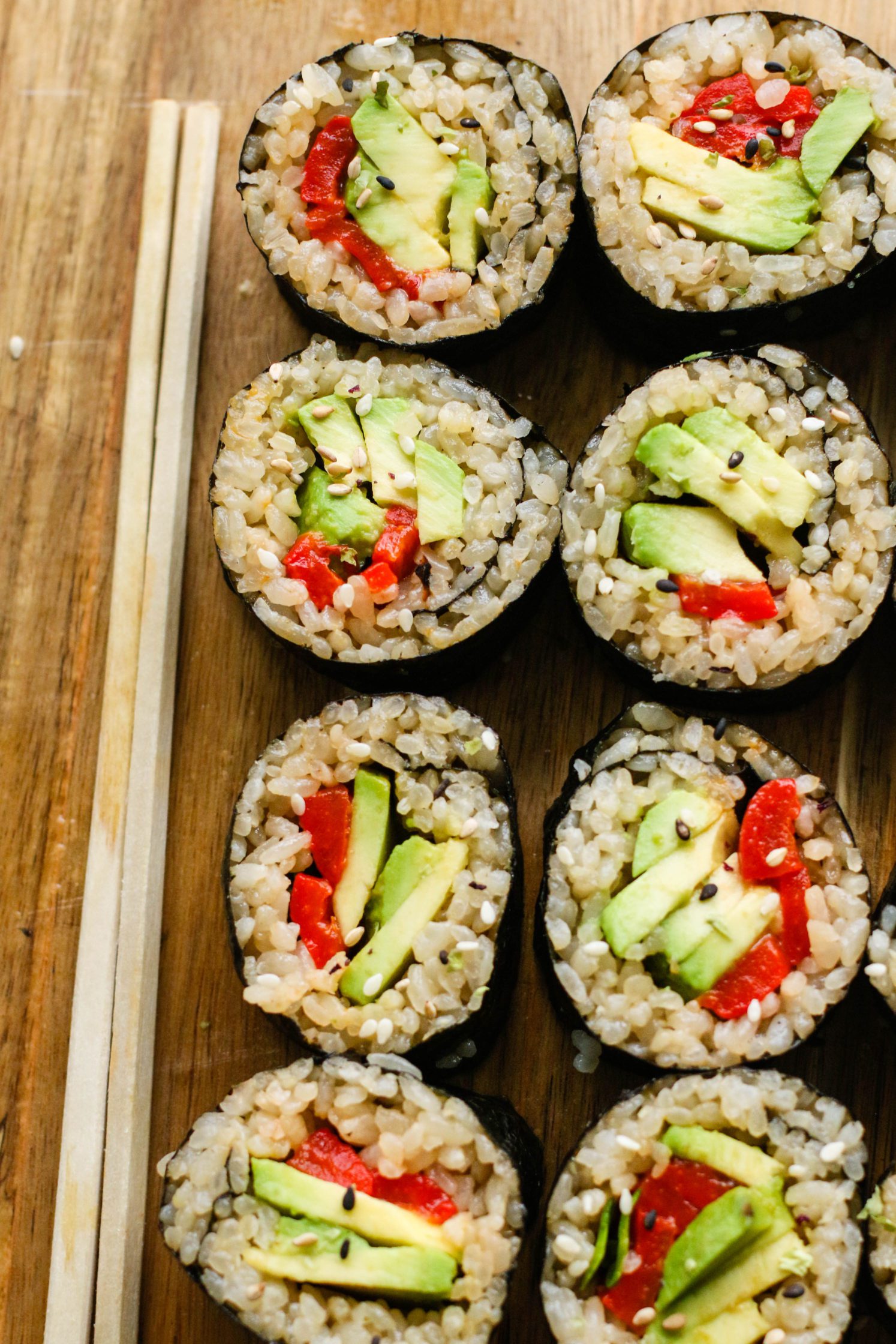 Vegan Avocado & Roasted Red Pepper Sushi served on wooden board with chopsticks by Flora & Vino