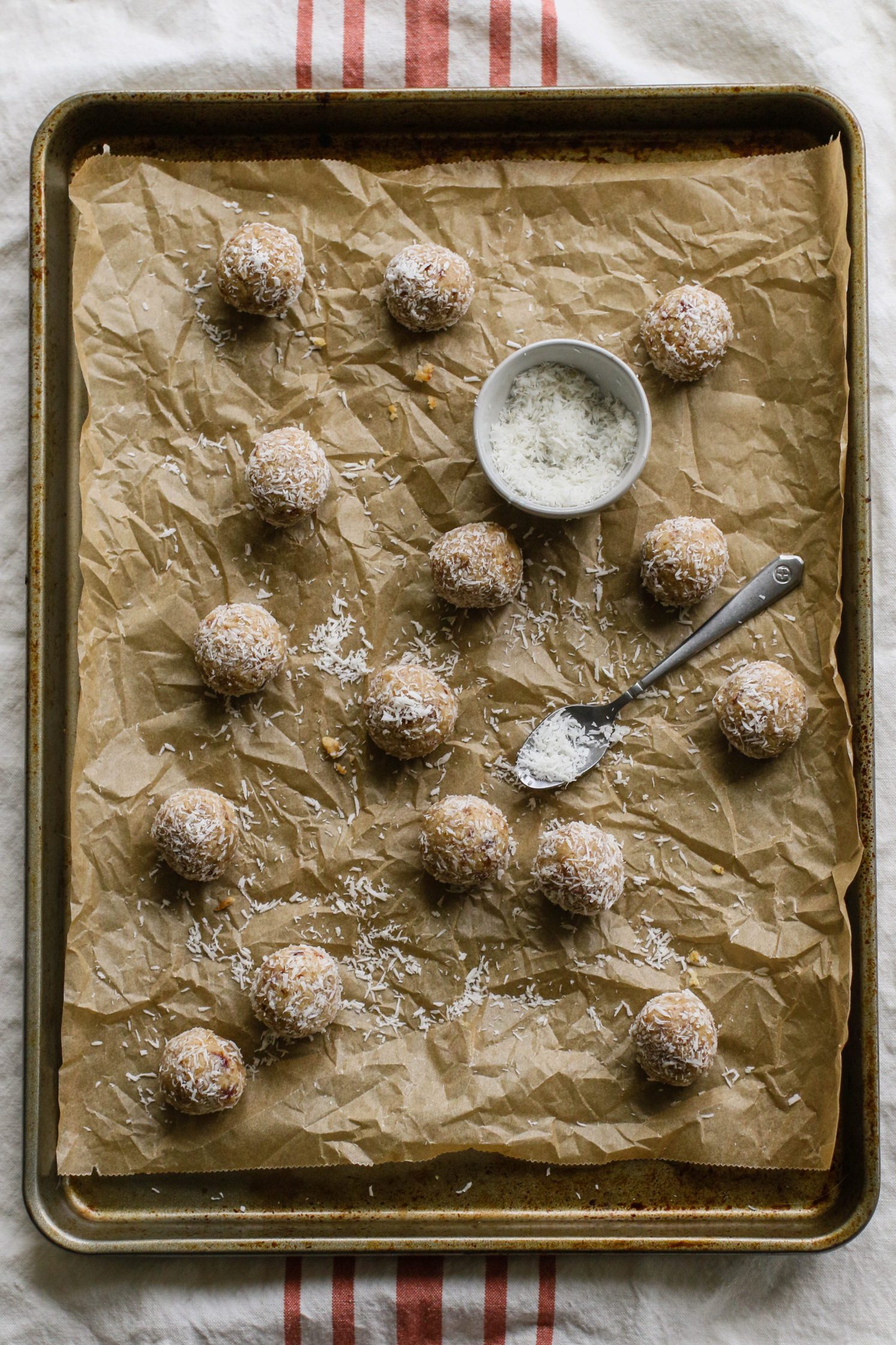 Coconut Cashew Cookie-Dough "Snowballs" rolled on parchment lined baking sheet by Flora & Vino