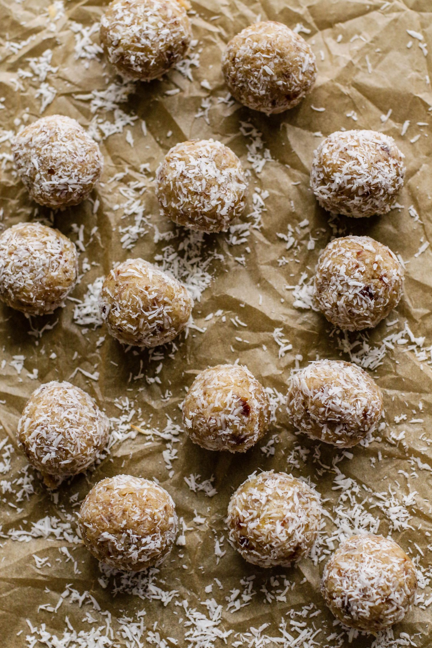 Coconut Cashew Cookie-Dough "Snowballs" served on parchment paper with shredded coconut by Flora & Vino