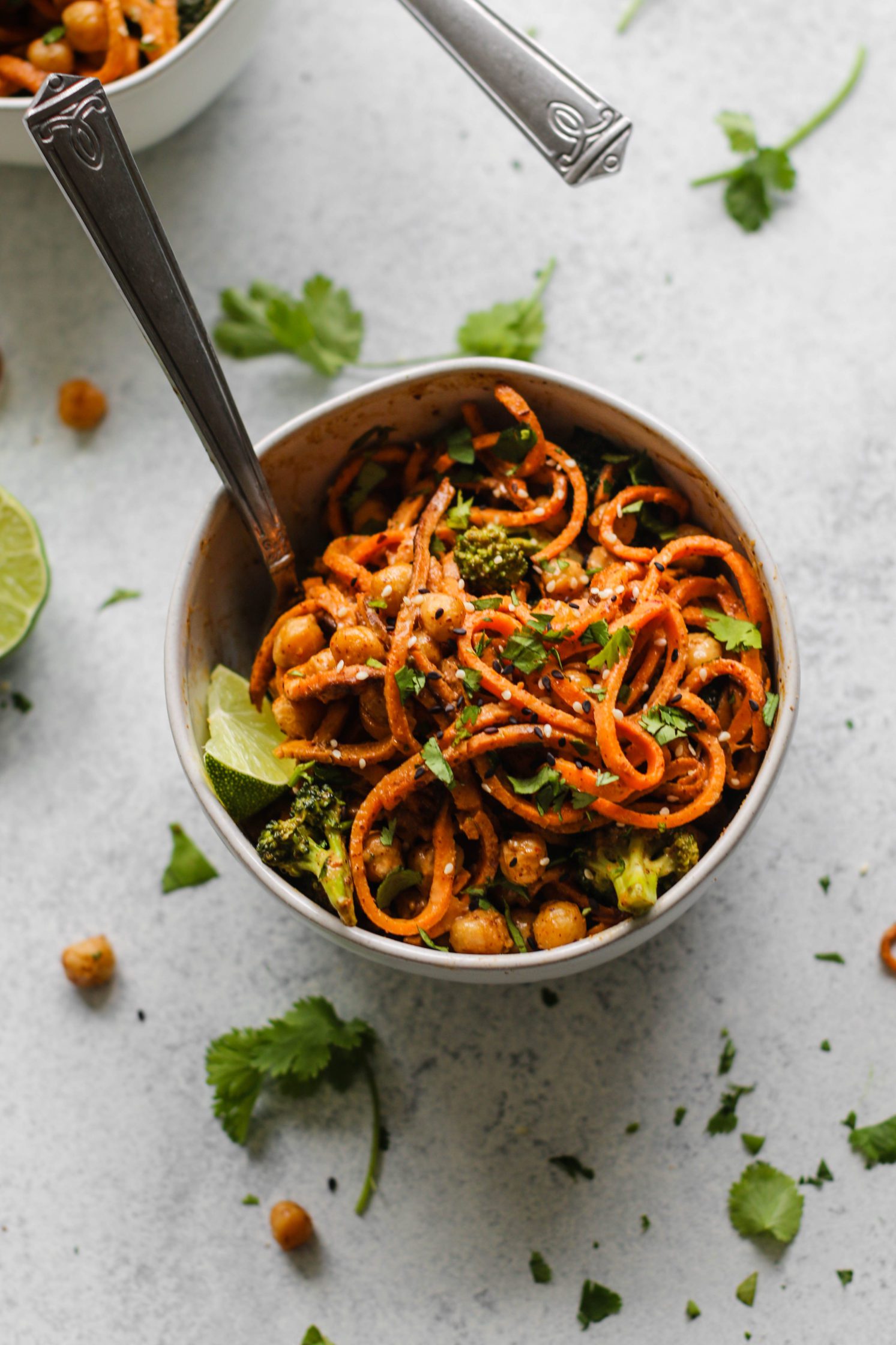 Spicy Almond Butter Sweet Potato Noodles served in a bowl with a fork by Flora & Vino