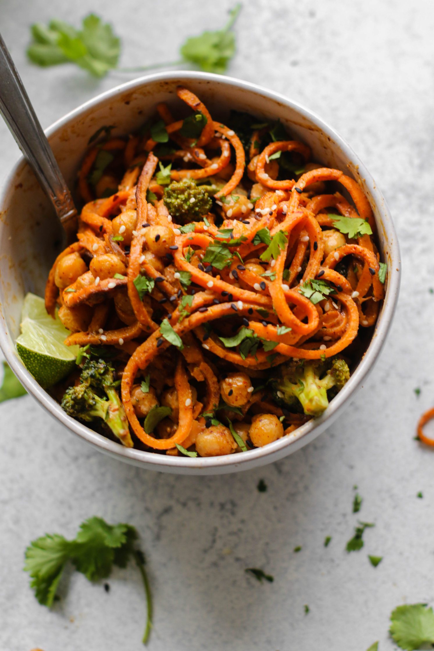 Spicy Almond Butter Sweet Potato Noodles served in a bowl with a fork by Flora & Vino