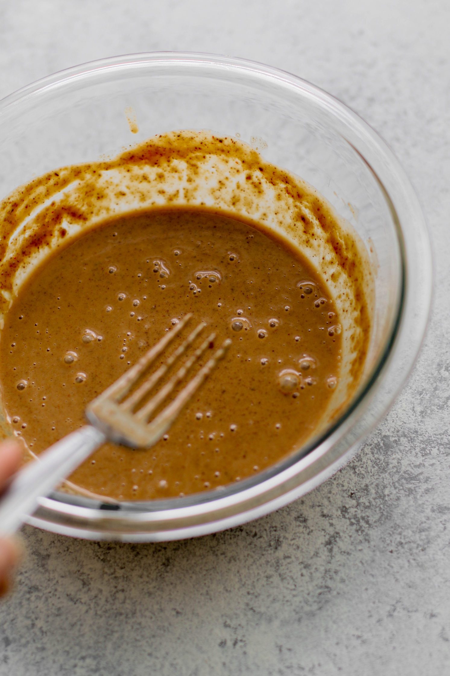 spicy almond butter sauce in bowl with fork by Flora & Vino