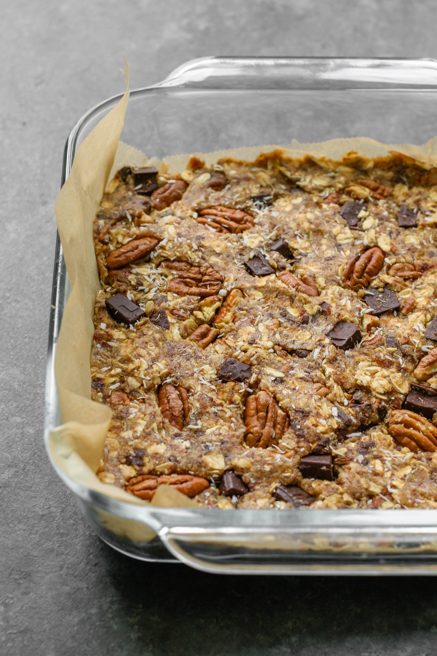 Healthy Magic Cookie Bars baked in parchment lined dish by Flora & Vino 