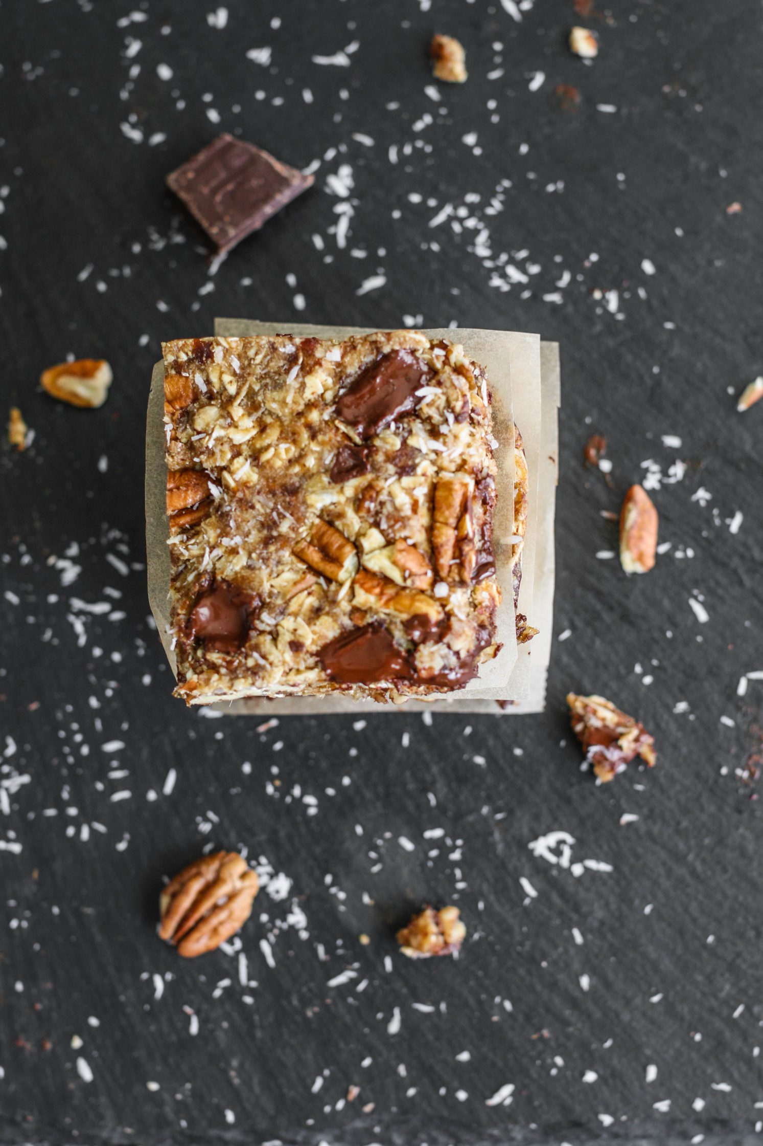 Healthy Magic Cookie Bars stacked on parchment paper by Flora & Vino 