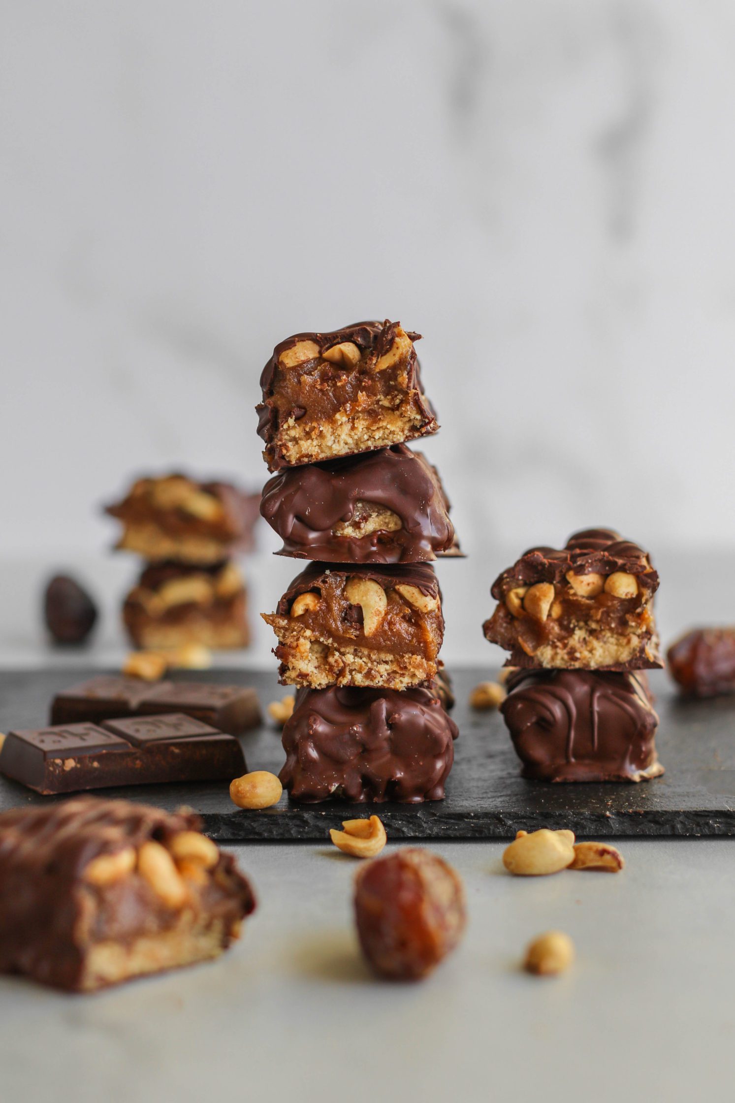 Vegan Salted Snickers Bars stacked on serving board by Flora & Vino