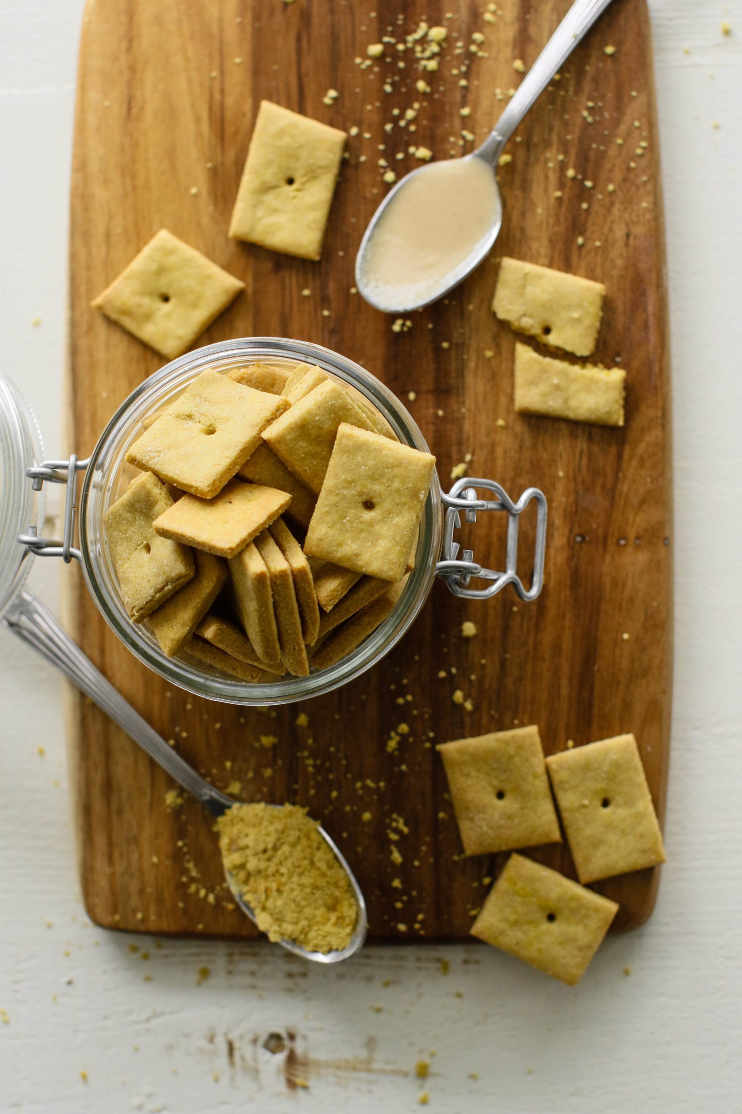Vegan tahini cheez-it's in jar with some scattered