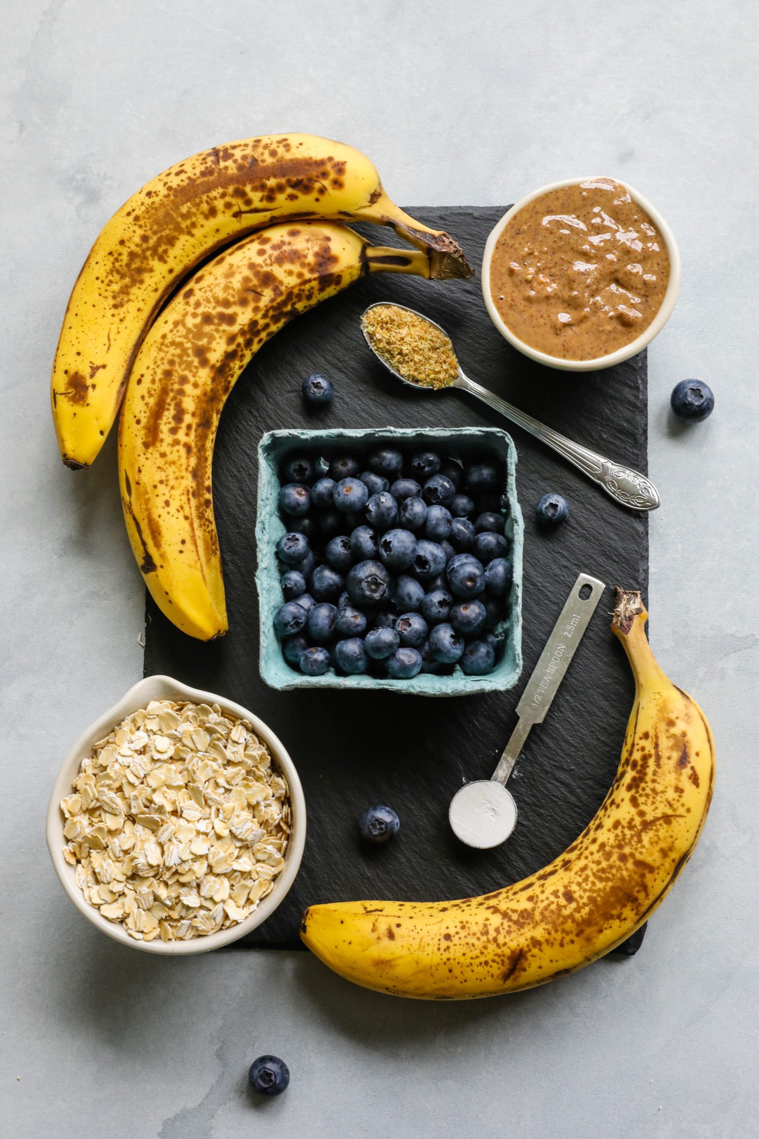 blueberries, banana, nut butter, and oats on serving board by Flora & Vino