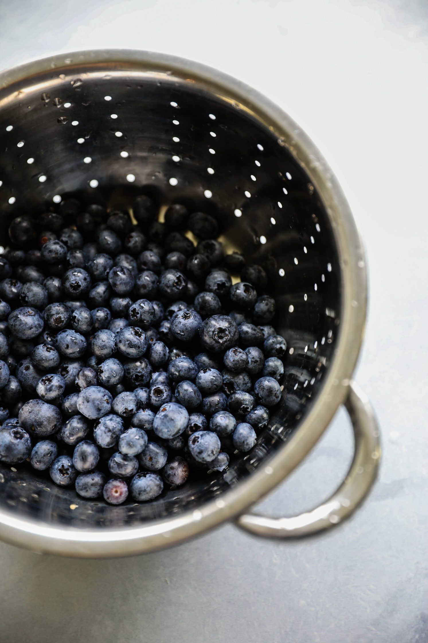 blueberries washed in colander by Flora & Vino